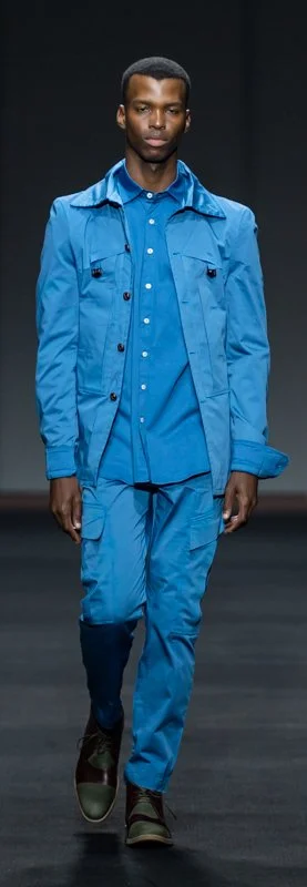 Male model in a blue outfit walking on the runway