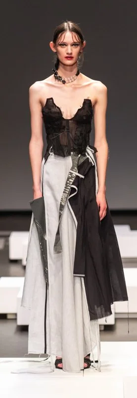 Model on runway wearing a black and white avant-garde outfit