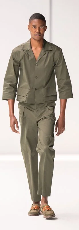 Model in olive green jacket and pants on runway