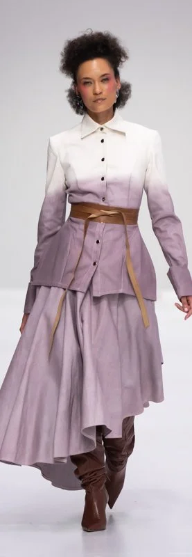 Model wearing a flowing gradient-dyed outfit with brown boots on a runway.