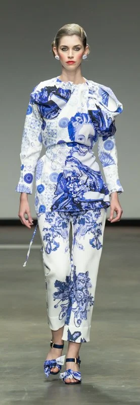 Model walking on runway wearing blue and white patterned outfit