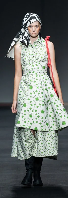 Model wearing floral-patterned dress and headscarf on runway