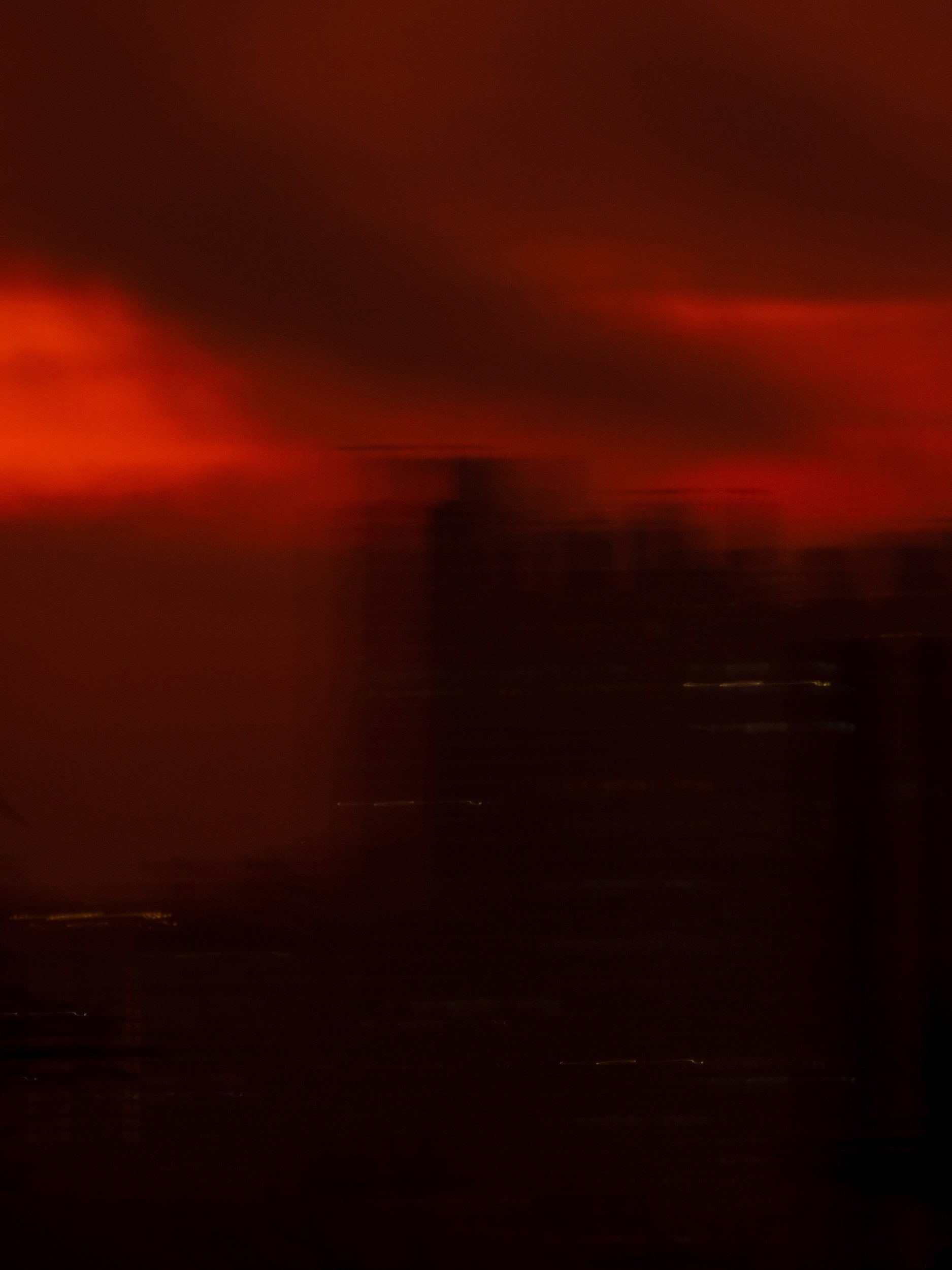 Abstract blurry image with red, black, and dark orange colors, no clear objects or details.