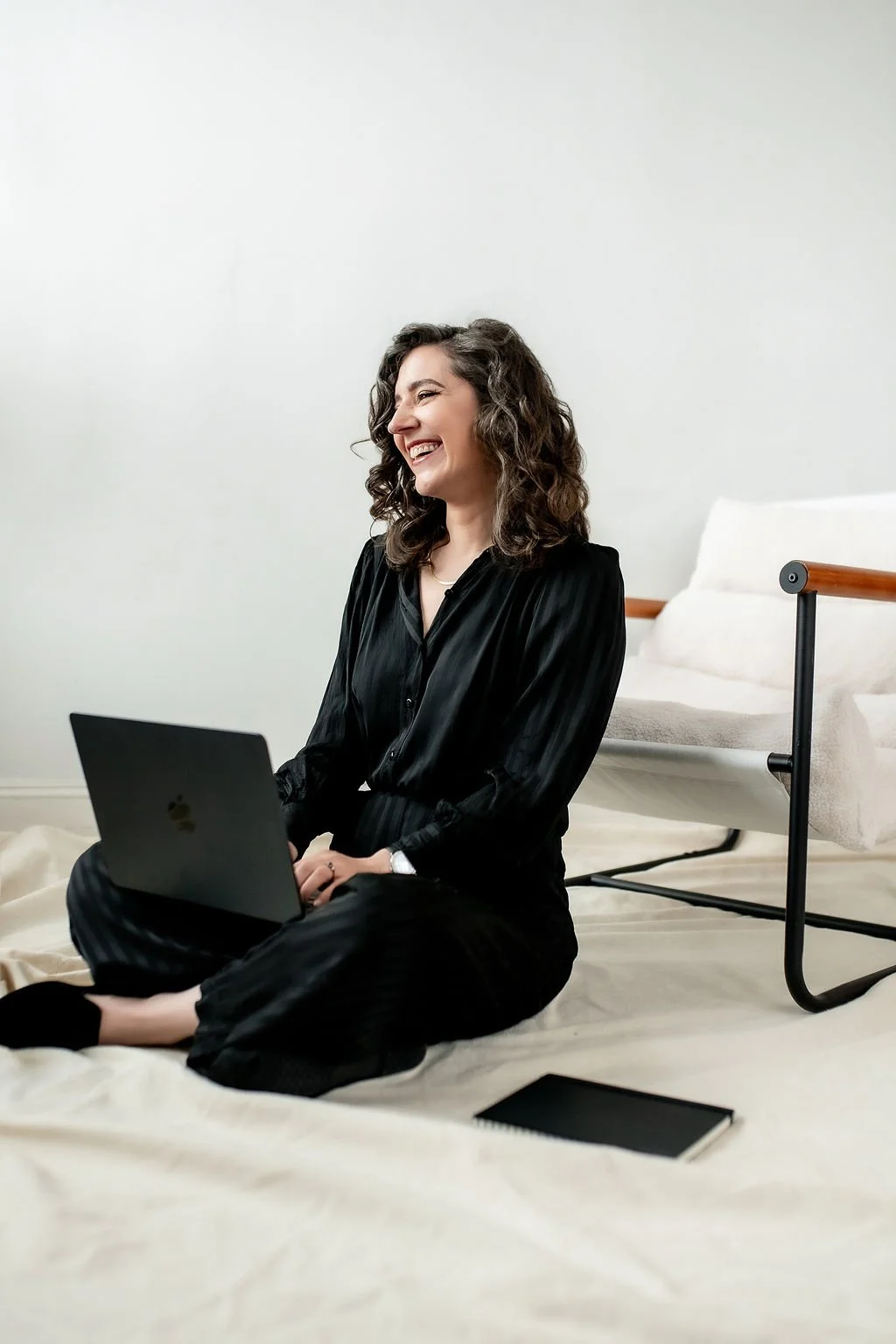 Image of Rikki Goldenberg, Career Coach, Executive Leadership Coach, seated wearing all black, working on a computer