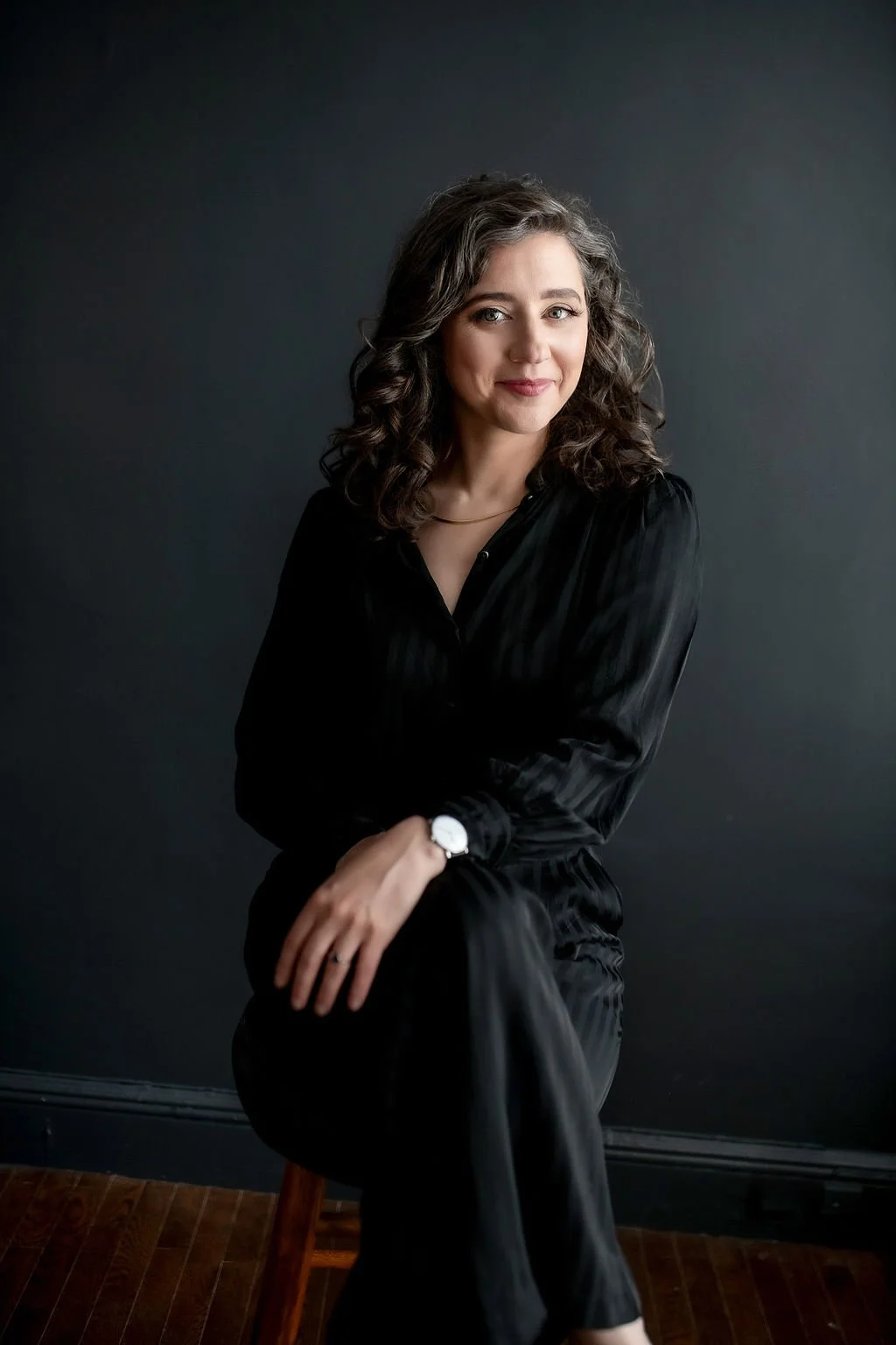 Rikki Goldenberg, Career and Leadership Coach  smiling and sitting on a chair