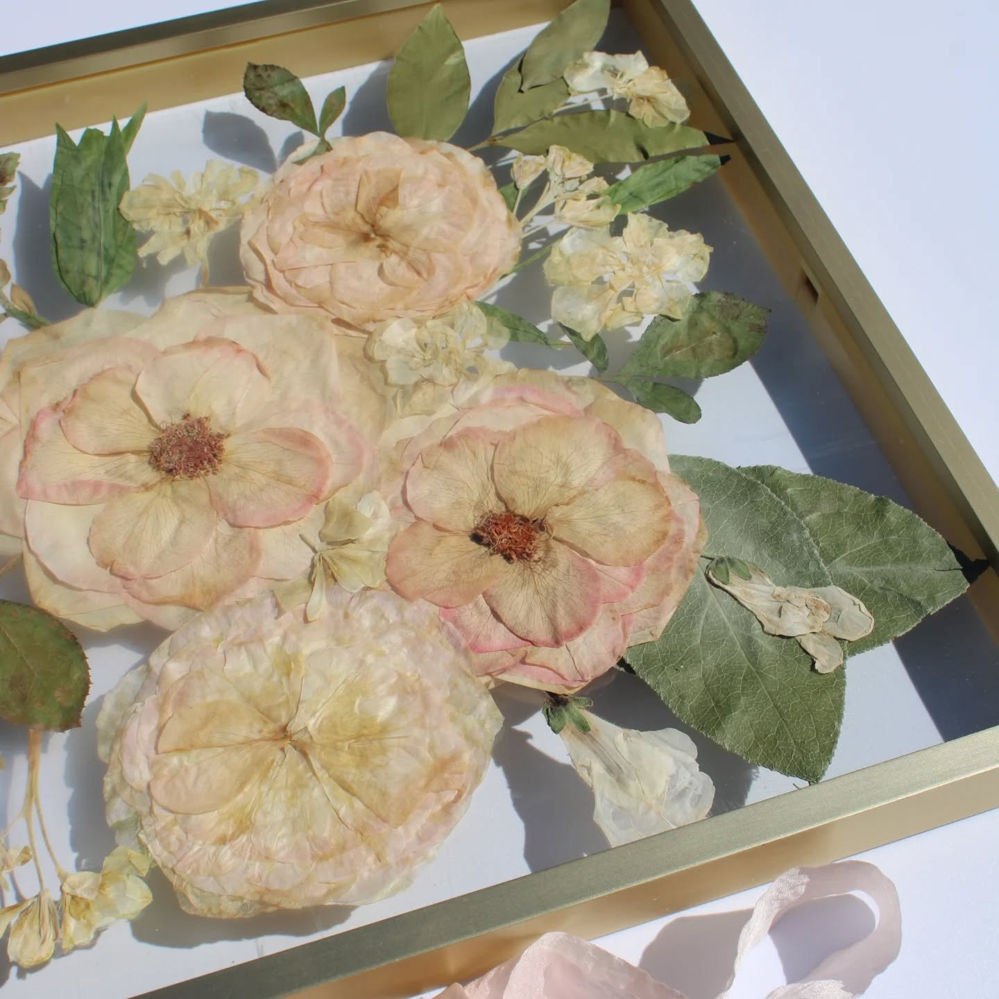 Blush blooms, layered greens, and airy details in a gold floating frame and round resin earrings. 🌸

It&rsquo;s the kind of keepsake that looks like art on your wall&hellip; and feels like a memory on your ears.

From statement piece to everyday acc