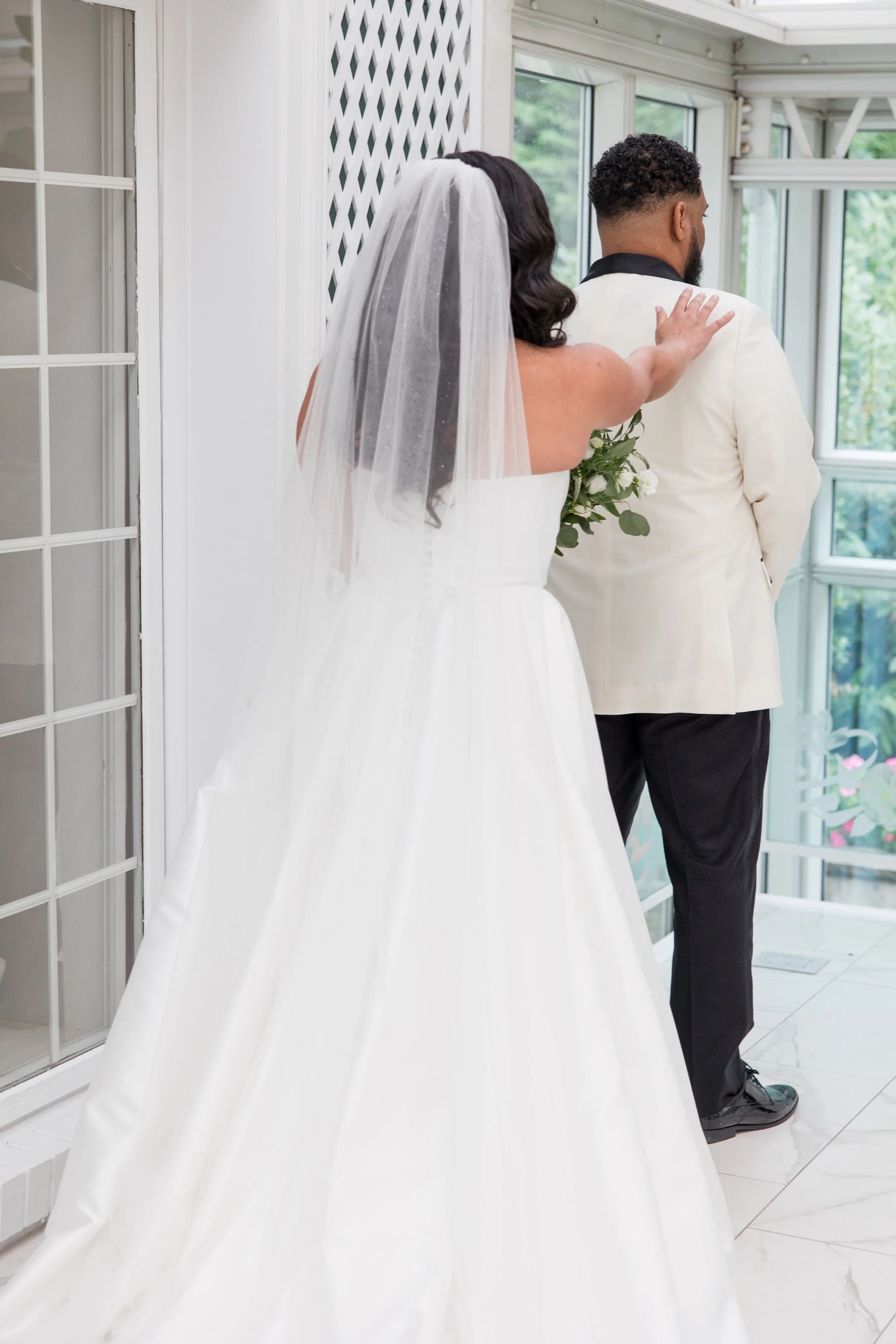 Bride tapping groom's shoulder during first look photo at The Park Savoy Estate in Florham Park, NJ by wedding photographer Jessica Anne Photography