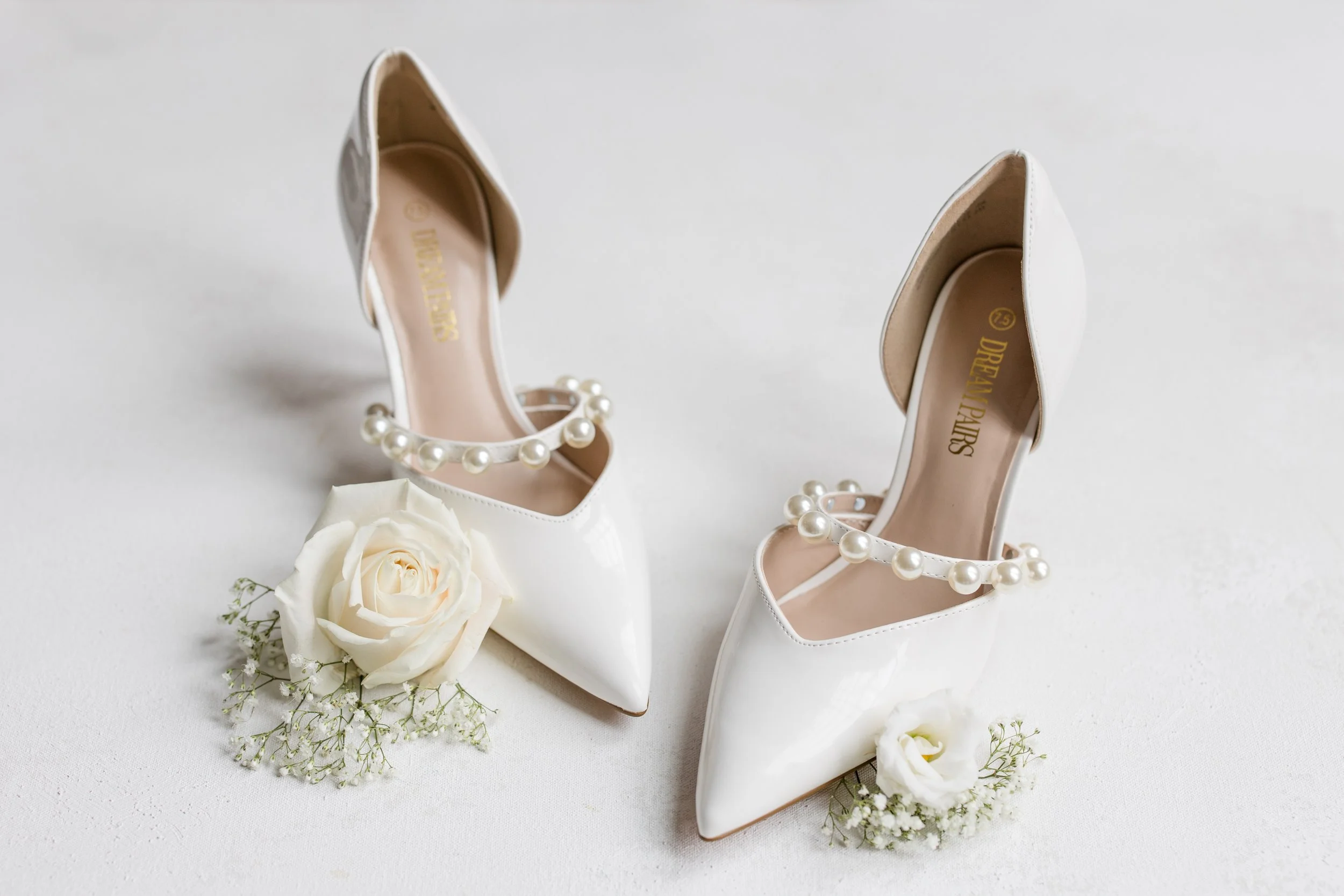 Wedding shoes details photo - white, pointed toed heals with pearls paired with white roses and babies breath. Photo by Jessica Anne Photography in New Jersey.