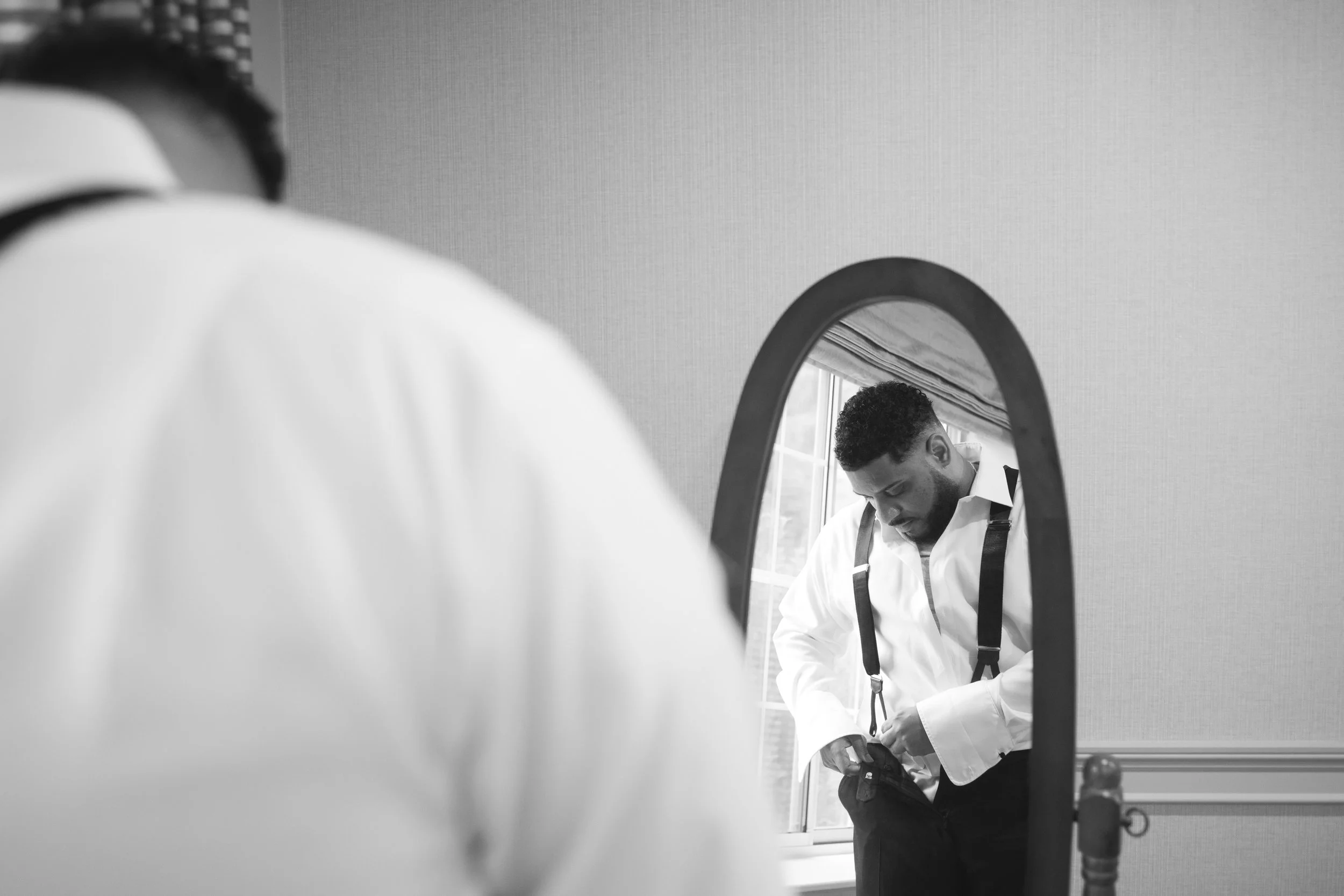 Groom getting ready in mirror. Black and white photo by New Jersey wedding photographer Jessica Anne Photography