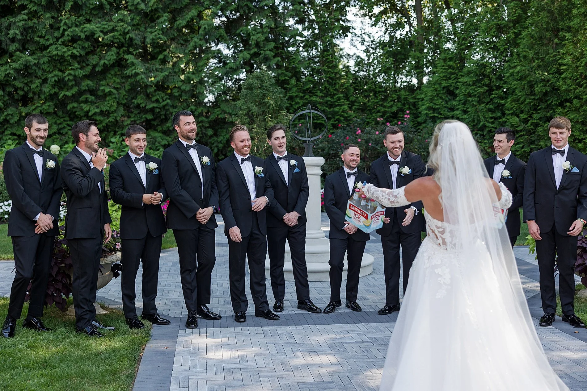  groomsmen turn around to see bride with 6 packs of drinks  
