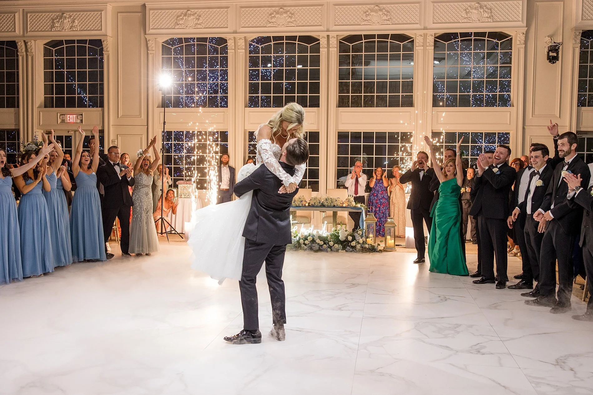  groom lifts bride up in his arms on dance floor 