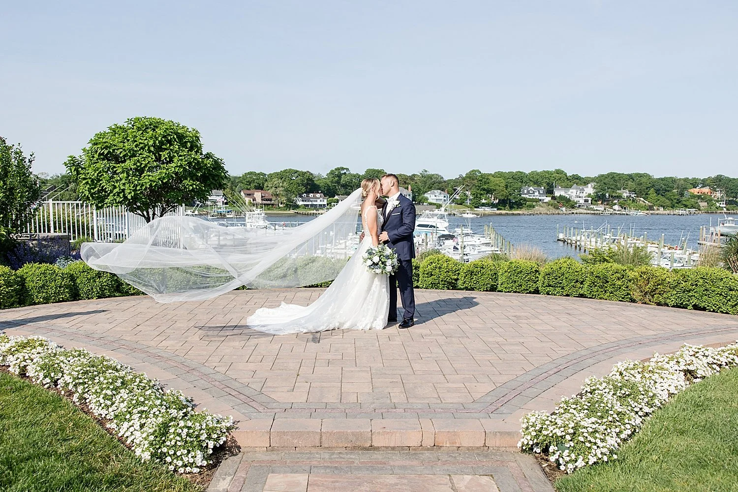 Bride and groom photos by the water at Crystal Point Yacht Club