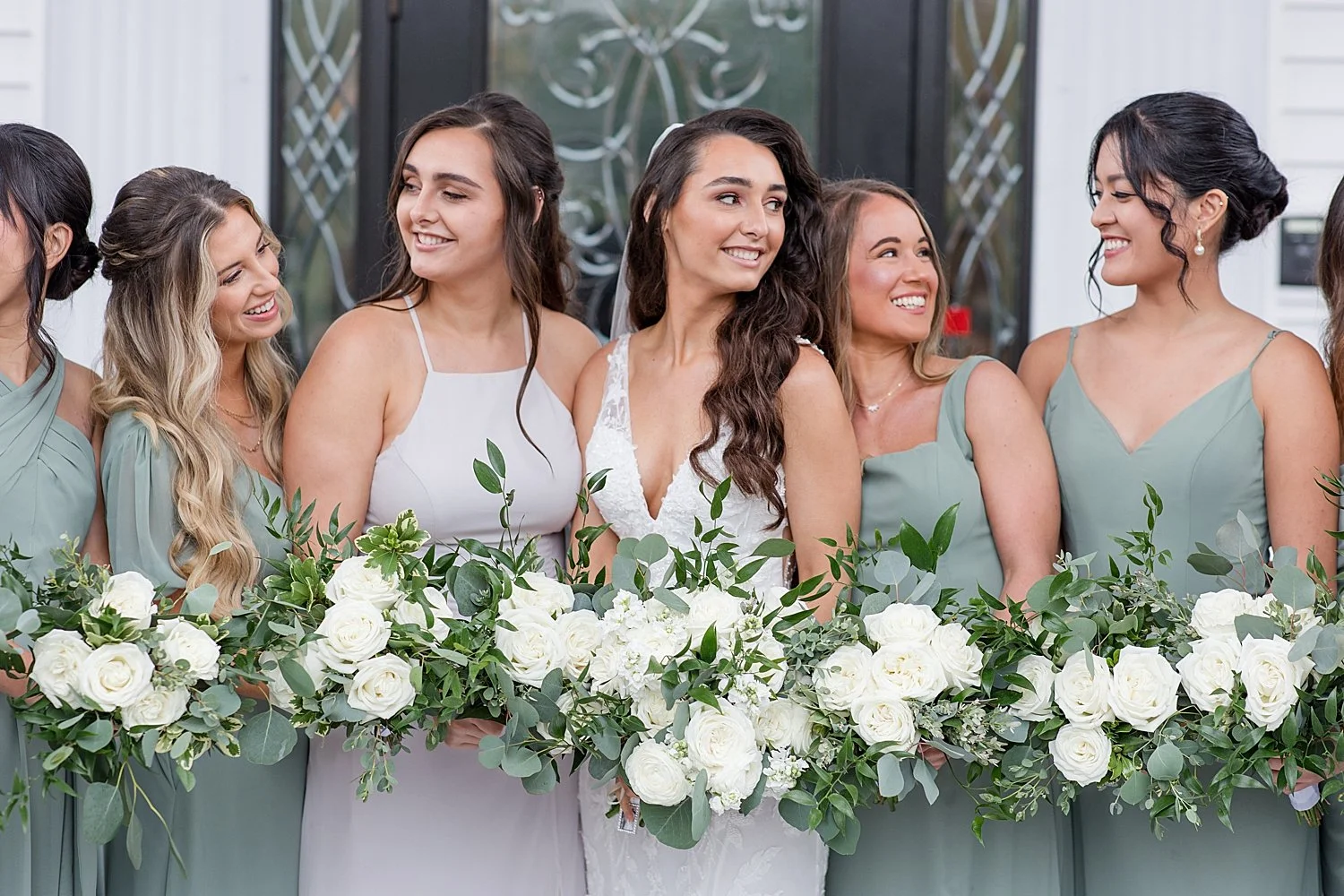  bridal party holding white flower bouquets  