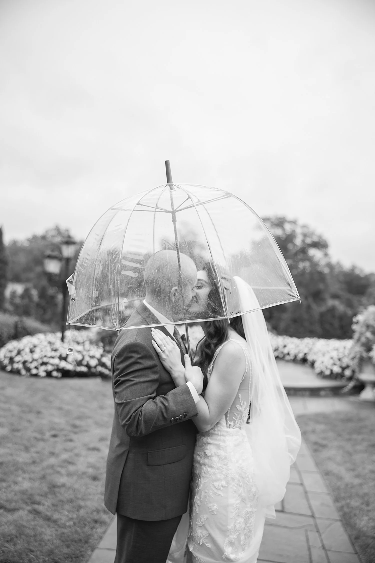  timeless wedding photos of bride and groom under clear umbrella in the rain  
