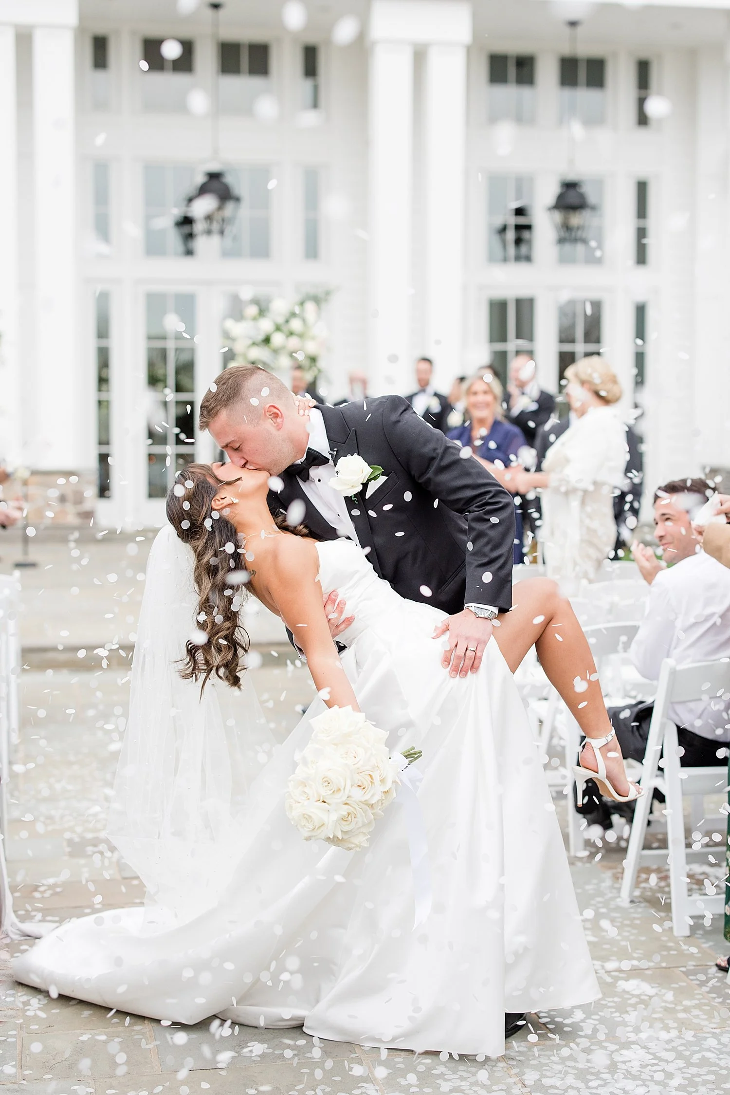  romantic epic kiss as newlyweds exit wedding ceremony while guests through confetti  