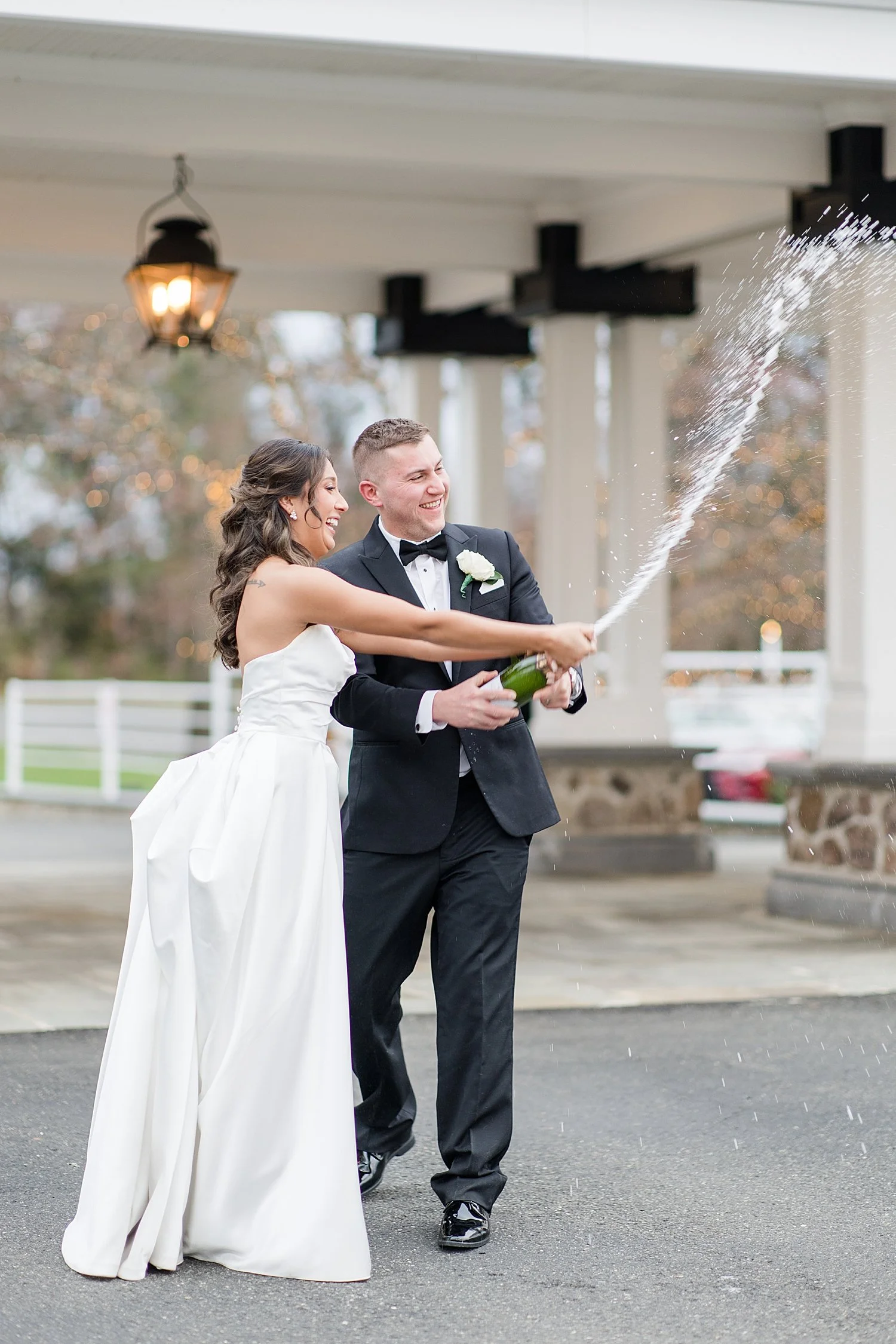  bride and groom open bottle of champagne as it sprays everywhere 