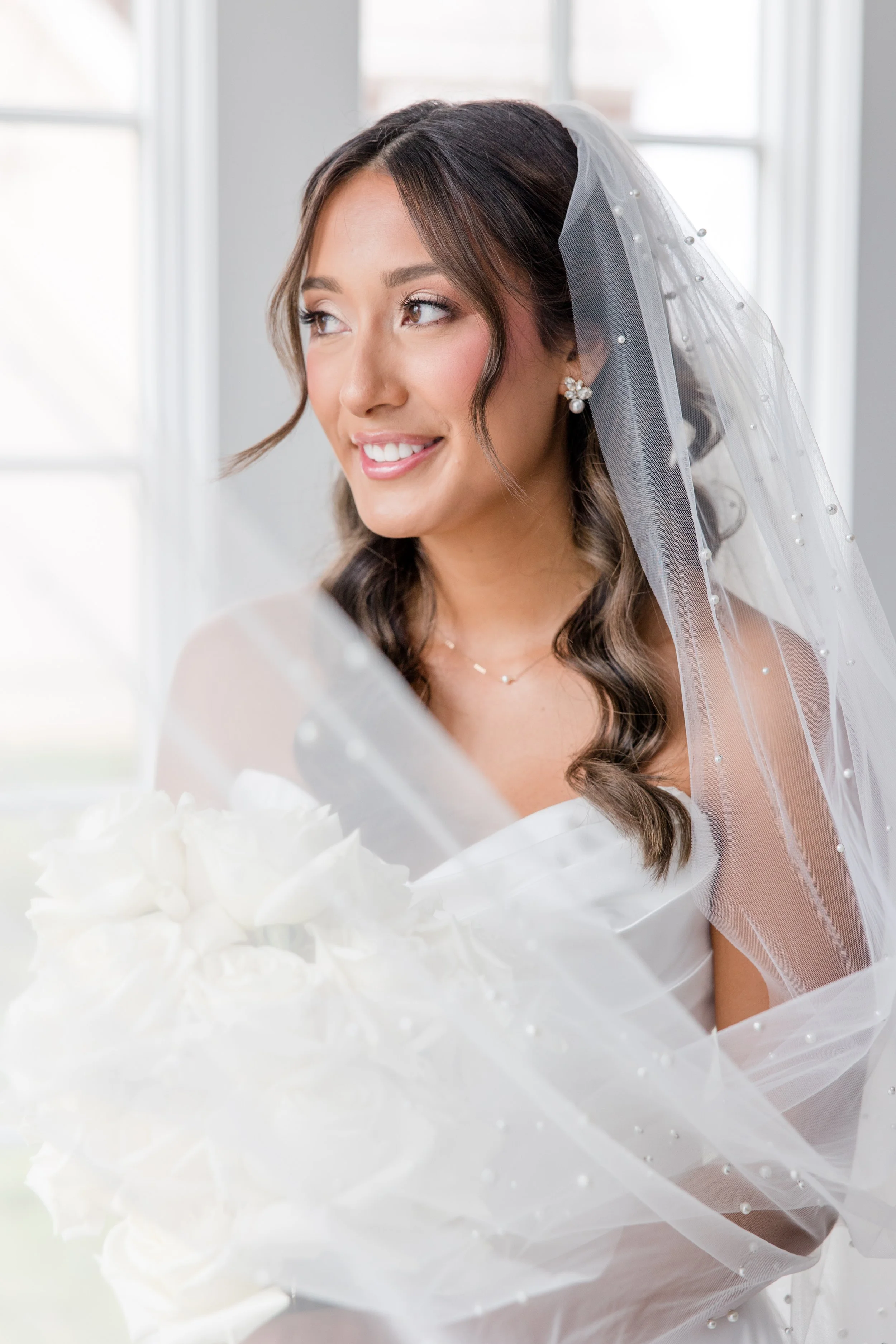 Swooping veil framing the bride holding bouquet in wedding photo by Jessica Anne Photography in NJ