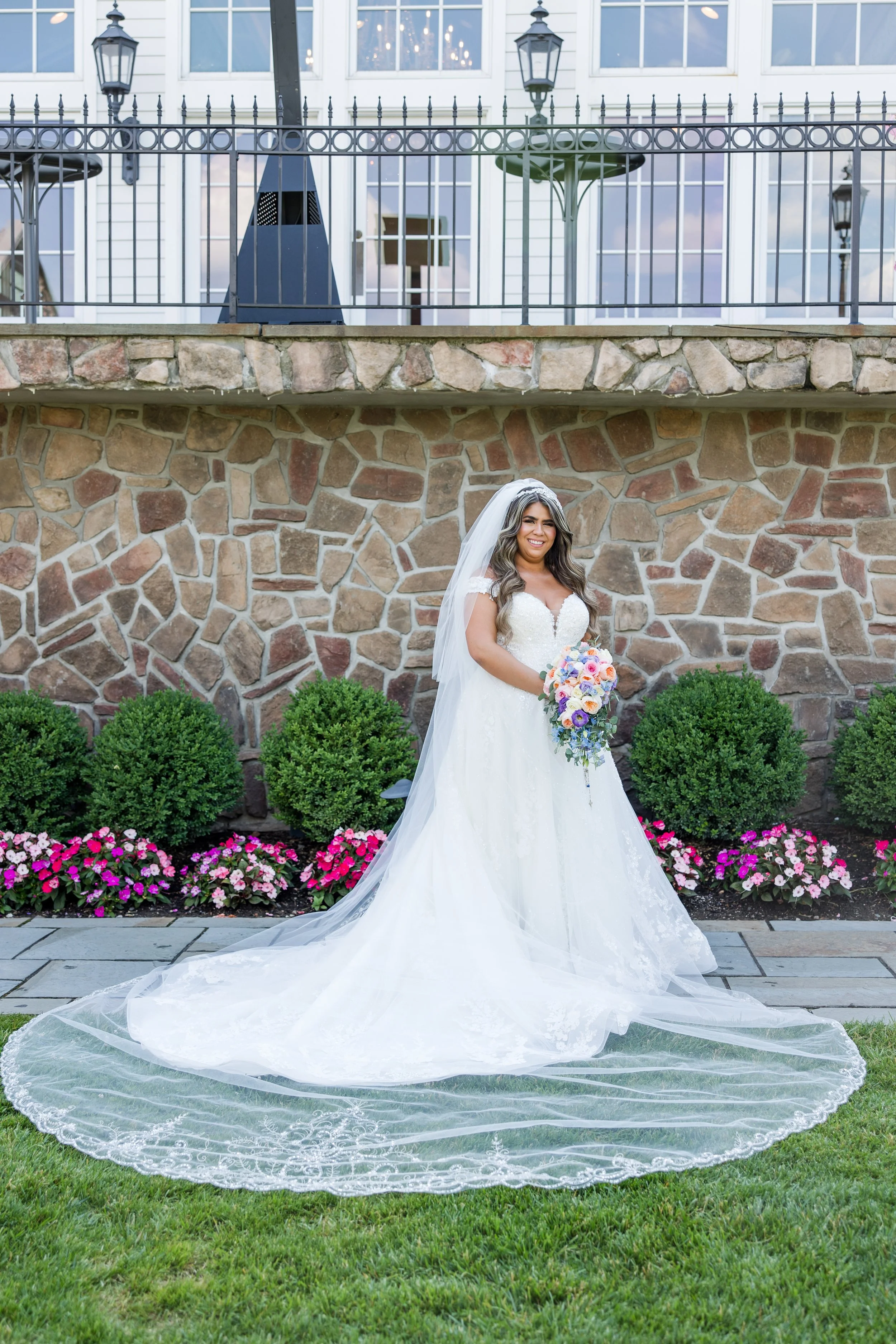 Bride solo shot with veil splayed on grass. Taken in front of The Park Savoy Estate in Florham Park, NJ by Jessica Anne Photography