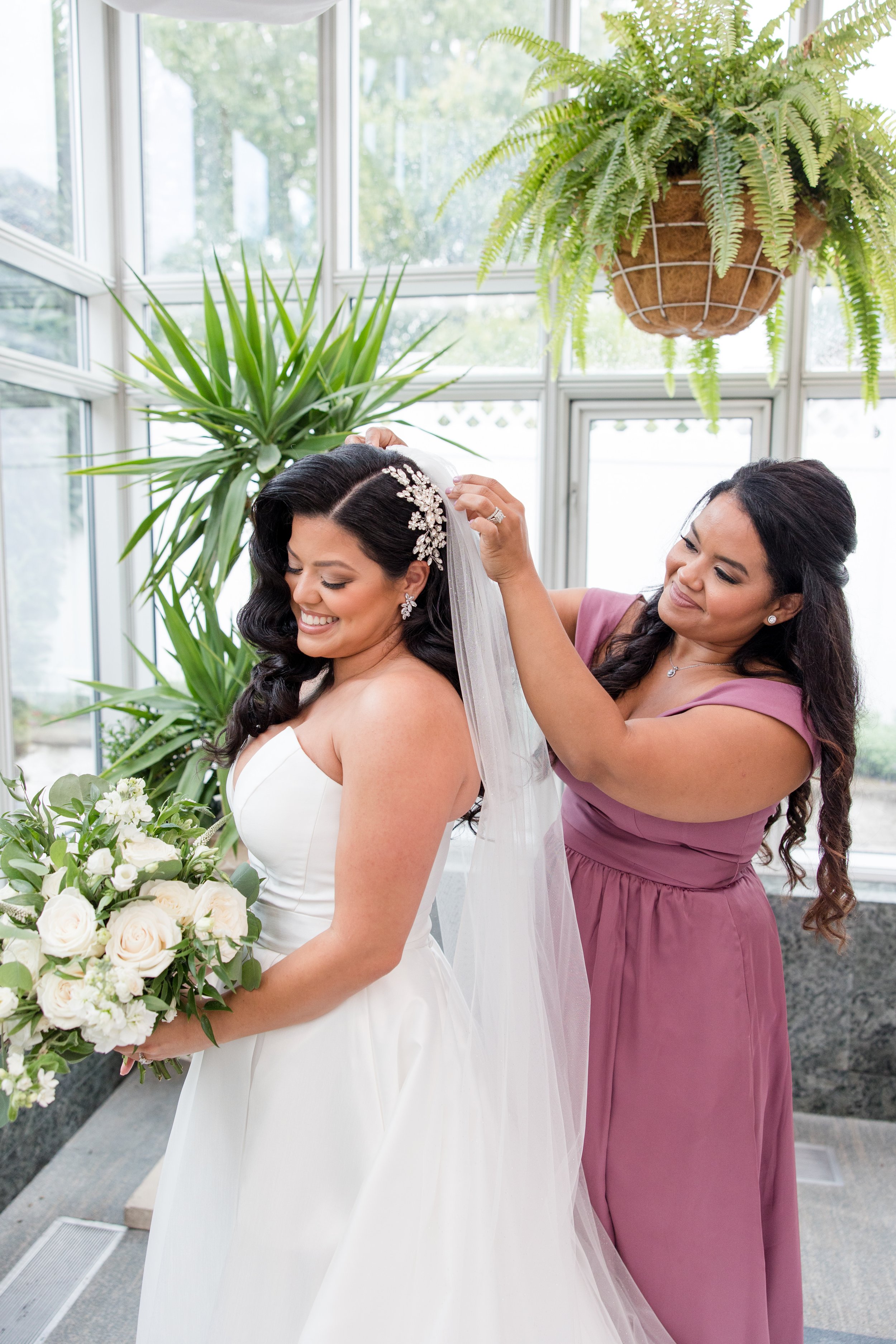 Maid of honor pinning bride's vei. Garden wedding photo taken at The Park Savoy Estate in Florham Park, NJ by Jessica Anne Photography