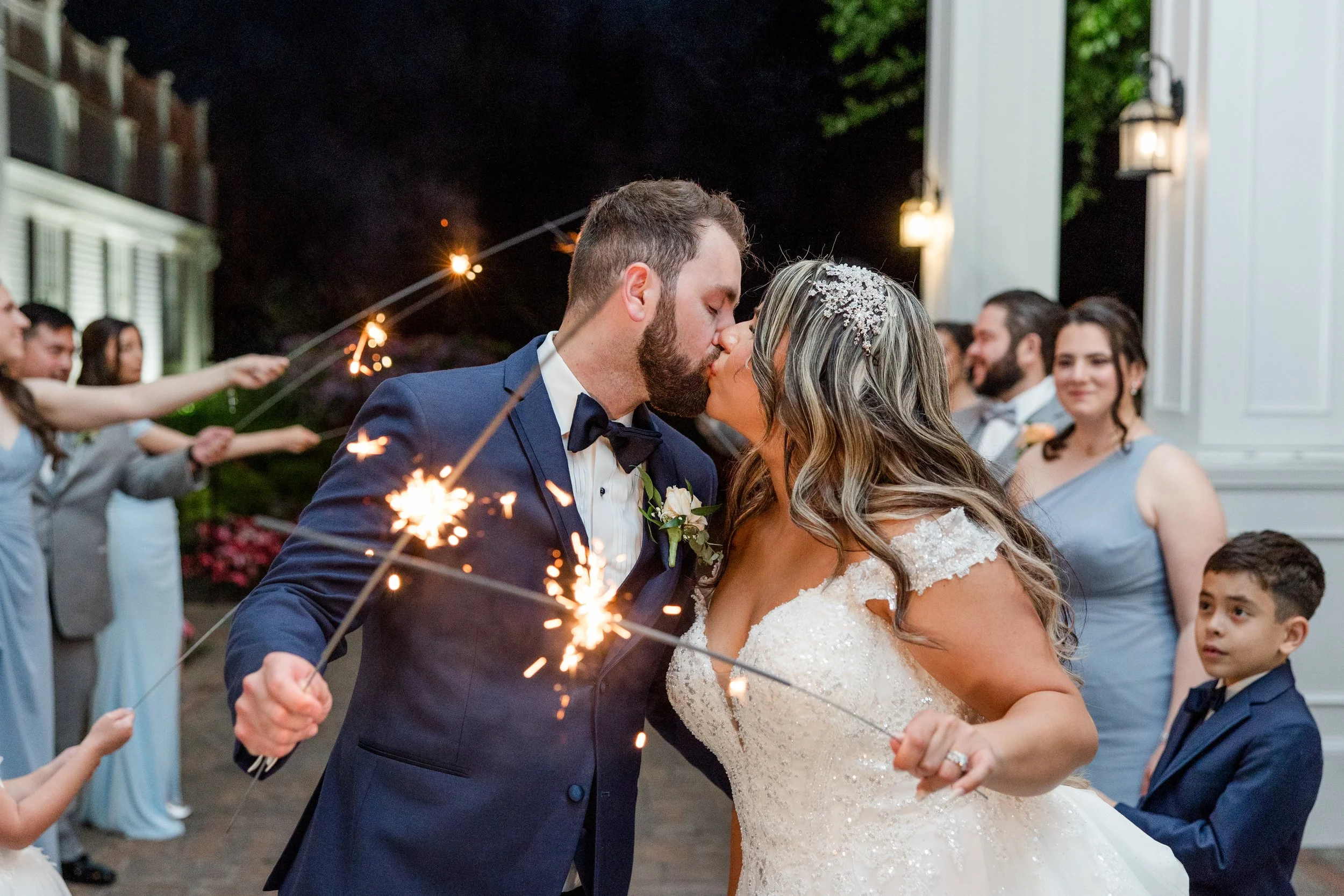 Bride and groom holding sparklers while kissing at The Park Savoy Estate in Florham Park, NJ. Wedding photo by Jessica Anne Photography