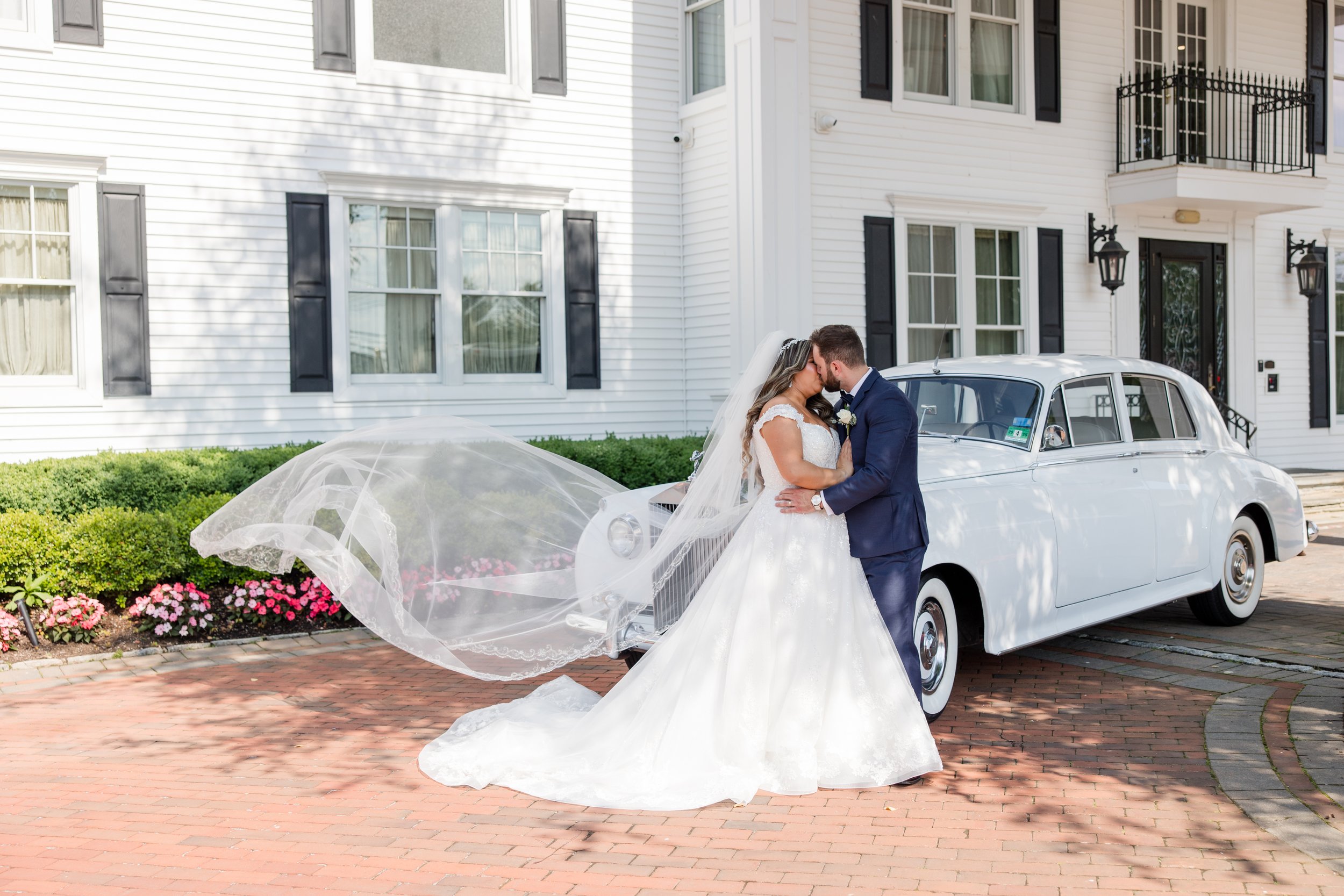 Bride and groom kissing with swooping veil in front of vintage car. Taken at The Park Savoy Estate in Florham Park, NJ by Jessica Anne Photography