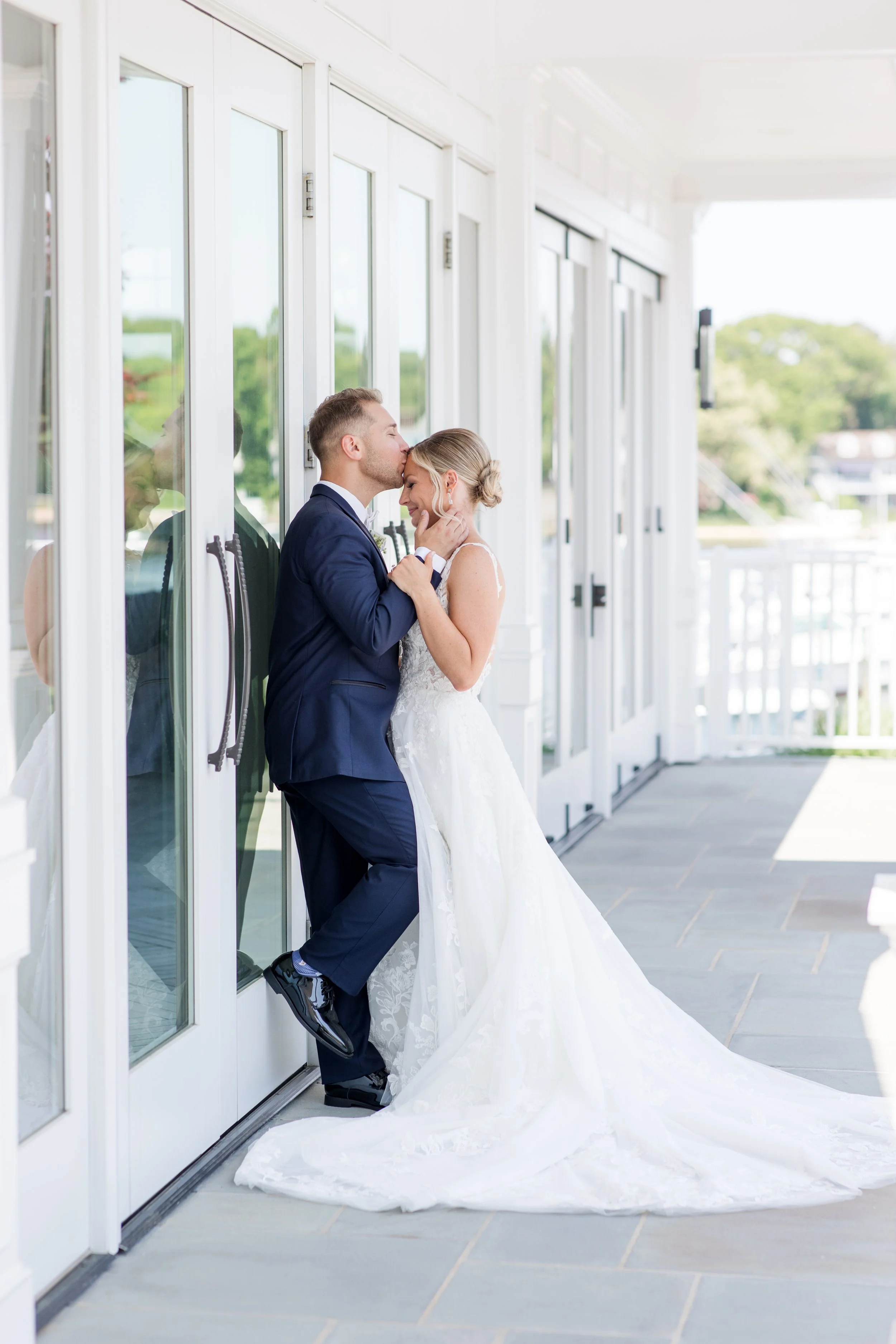 Romantic groom kissing bride's forehead photo at Crystal Point Yacht Club in Point Pleasant, NJ. Photo by Jessica Anne Photography