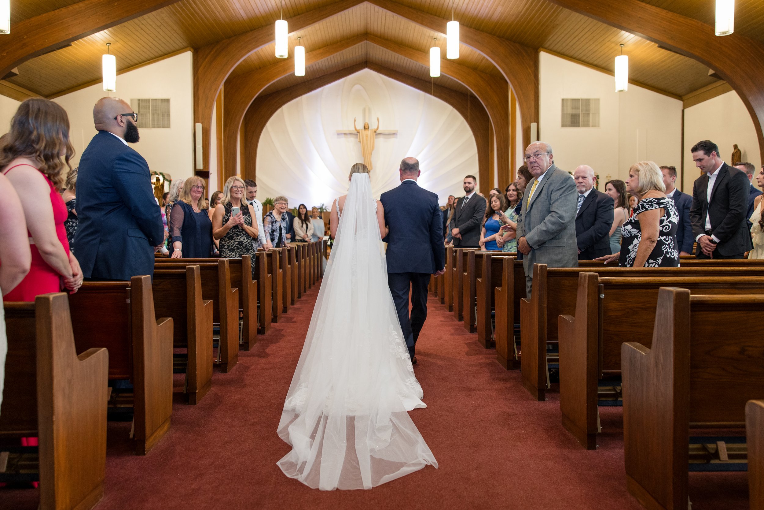 Bride and father walking down the aisle, veil trailing, at NJ Church wedding. Photo by Jessica Anne Photography