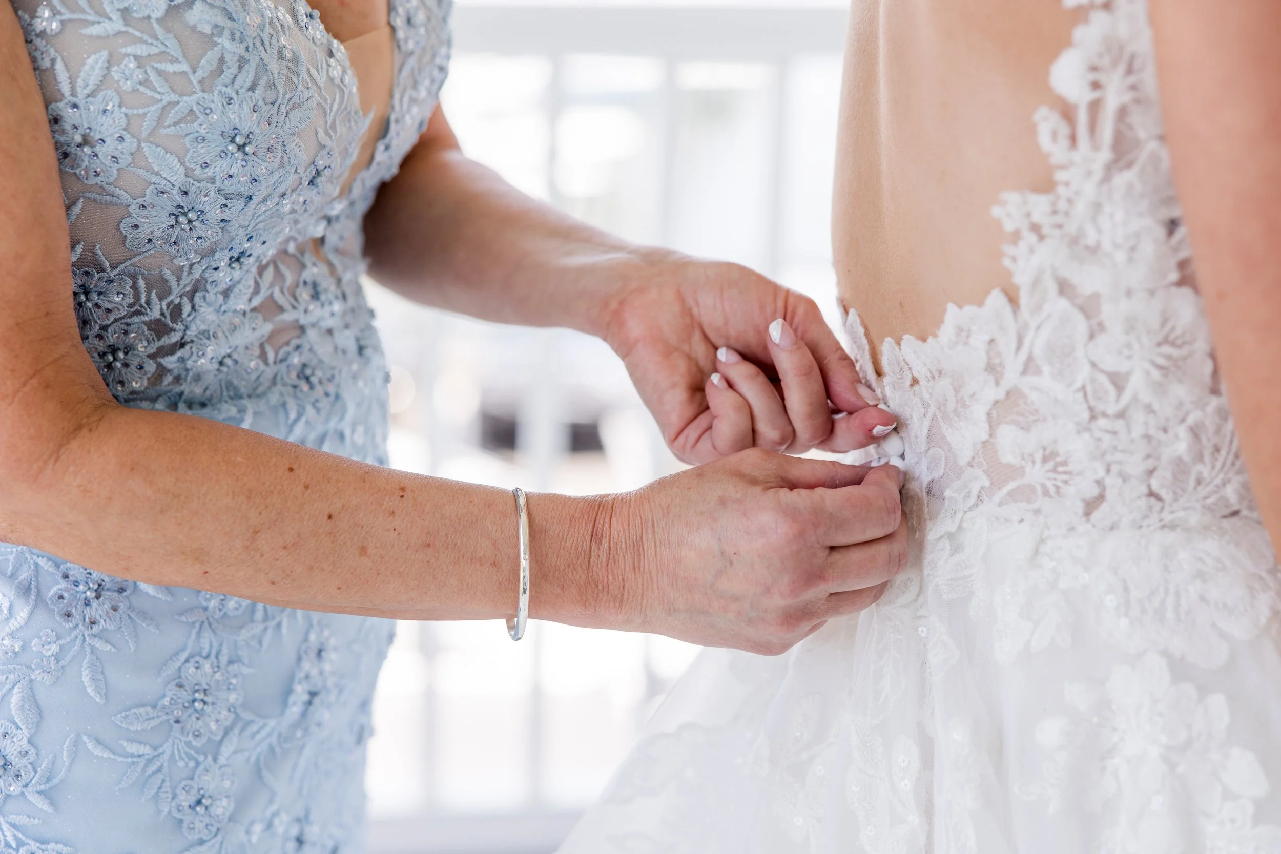 Closeup mother of the bride zipping up dress. Getting ready photo by Jessica Anne Photography at Crystal Point Yacht Club in Point Pleasant, NJ