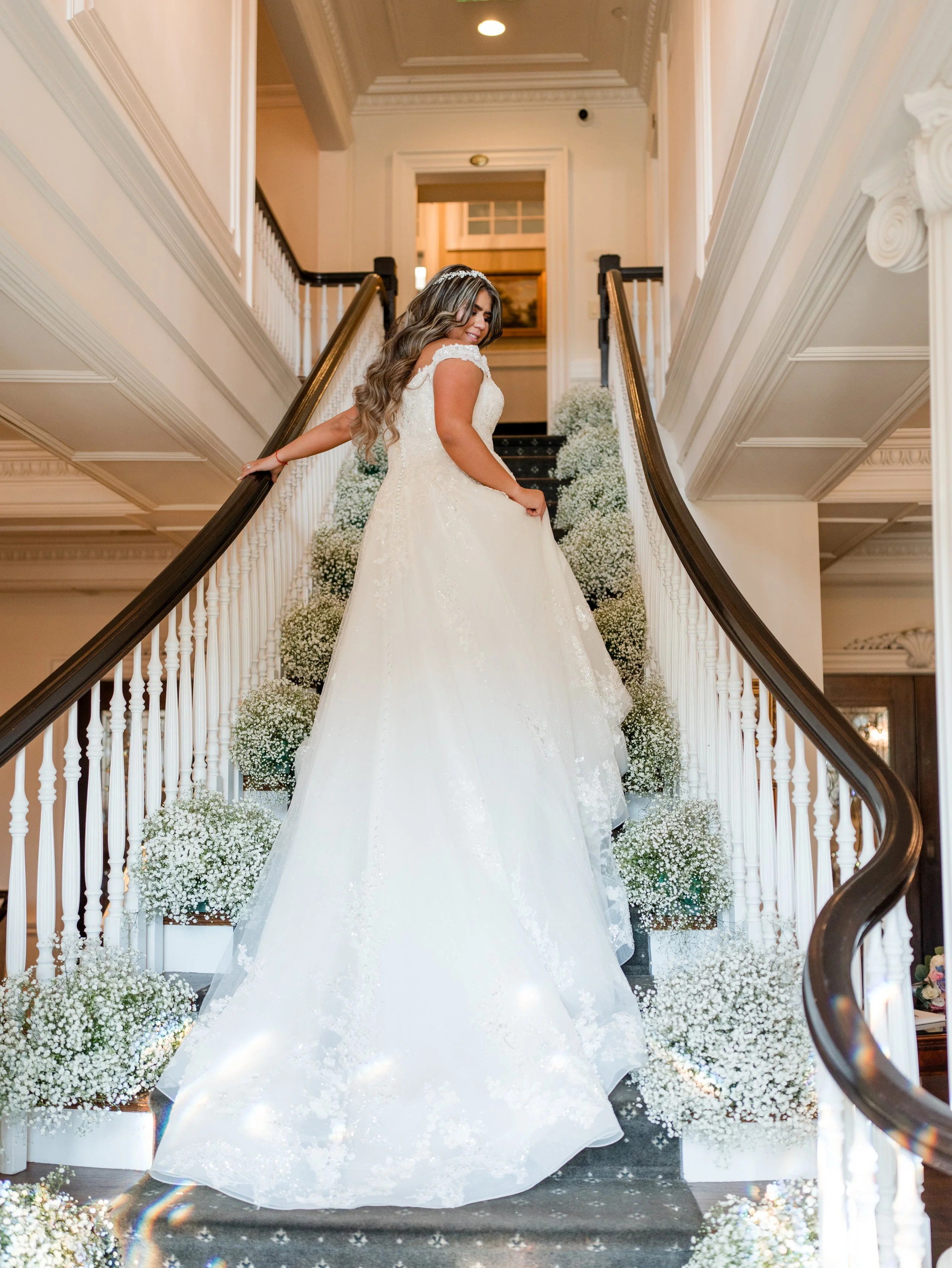 Bride on grand staircase with trail and veil trailing down steps at The Park Savoy Estate in Florham Park, NJ by wedding photographer, Jessica Anne Photography