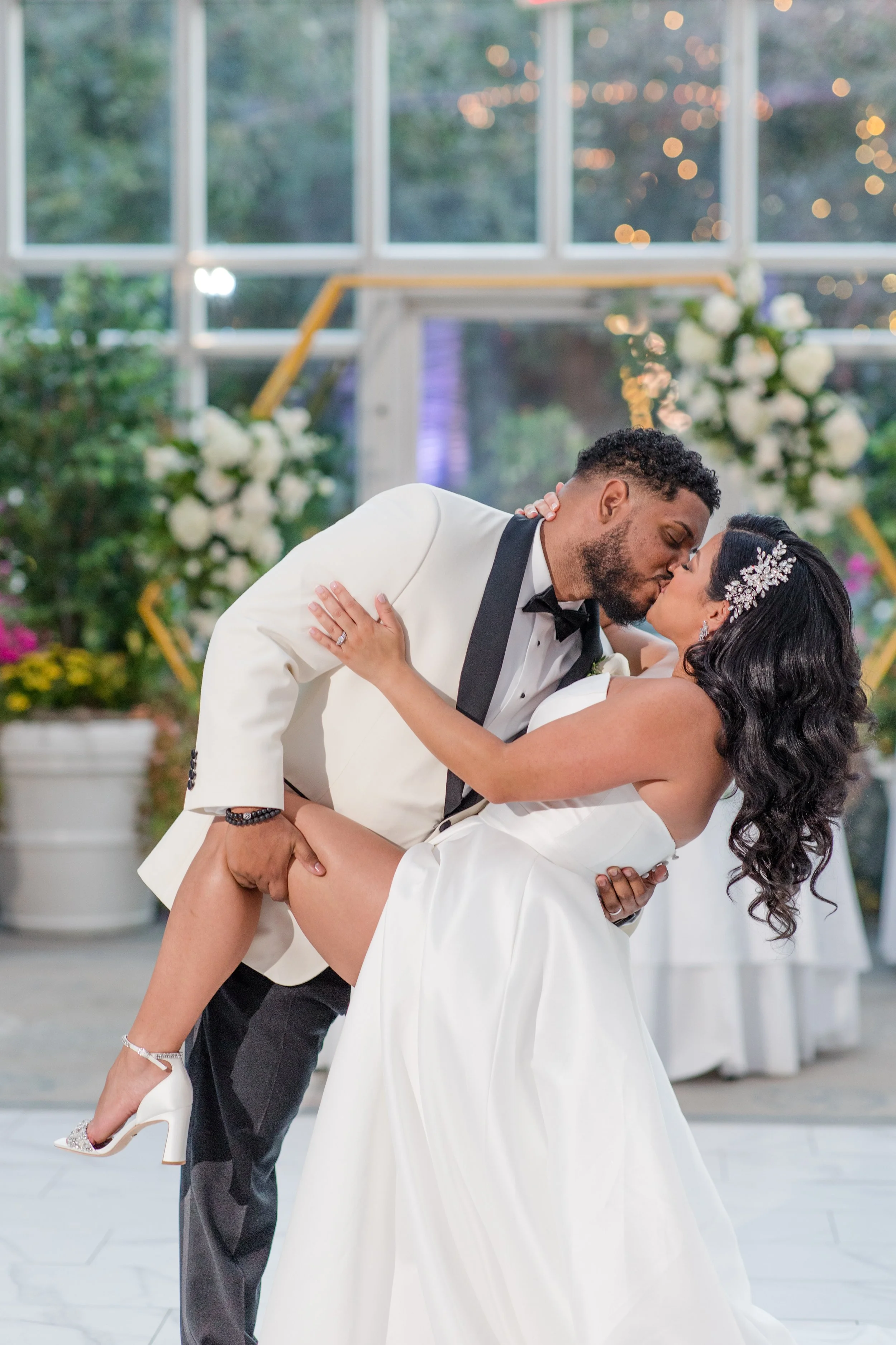 Groom dipping bride in front of arch at greenhouse wedding at The Park Savoy Estate in Florham Park, NJ. Photo by Jessica Anne Photography