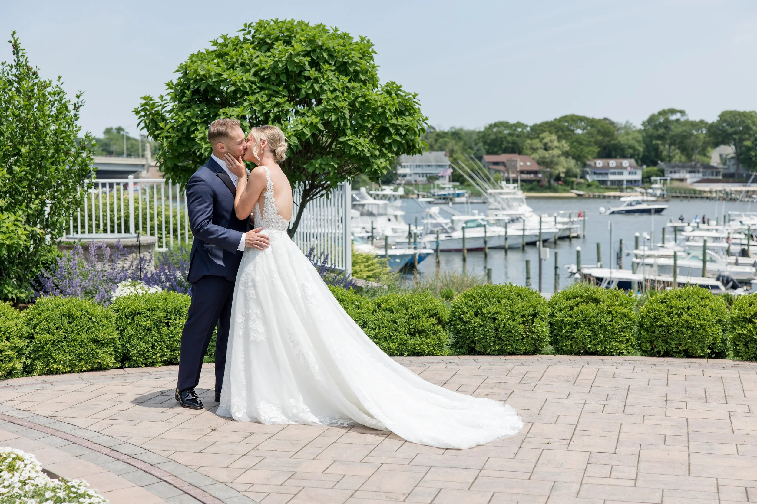 Newly weds kissing on the water at Crystal Point Yacht Club in Point Pleasant, NJ. Photo by Jessica Anne Photography