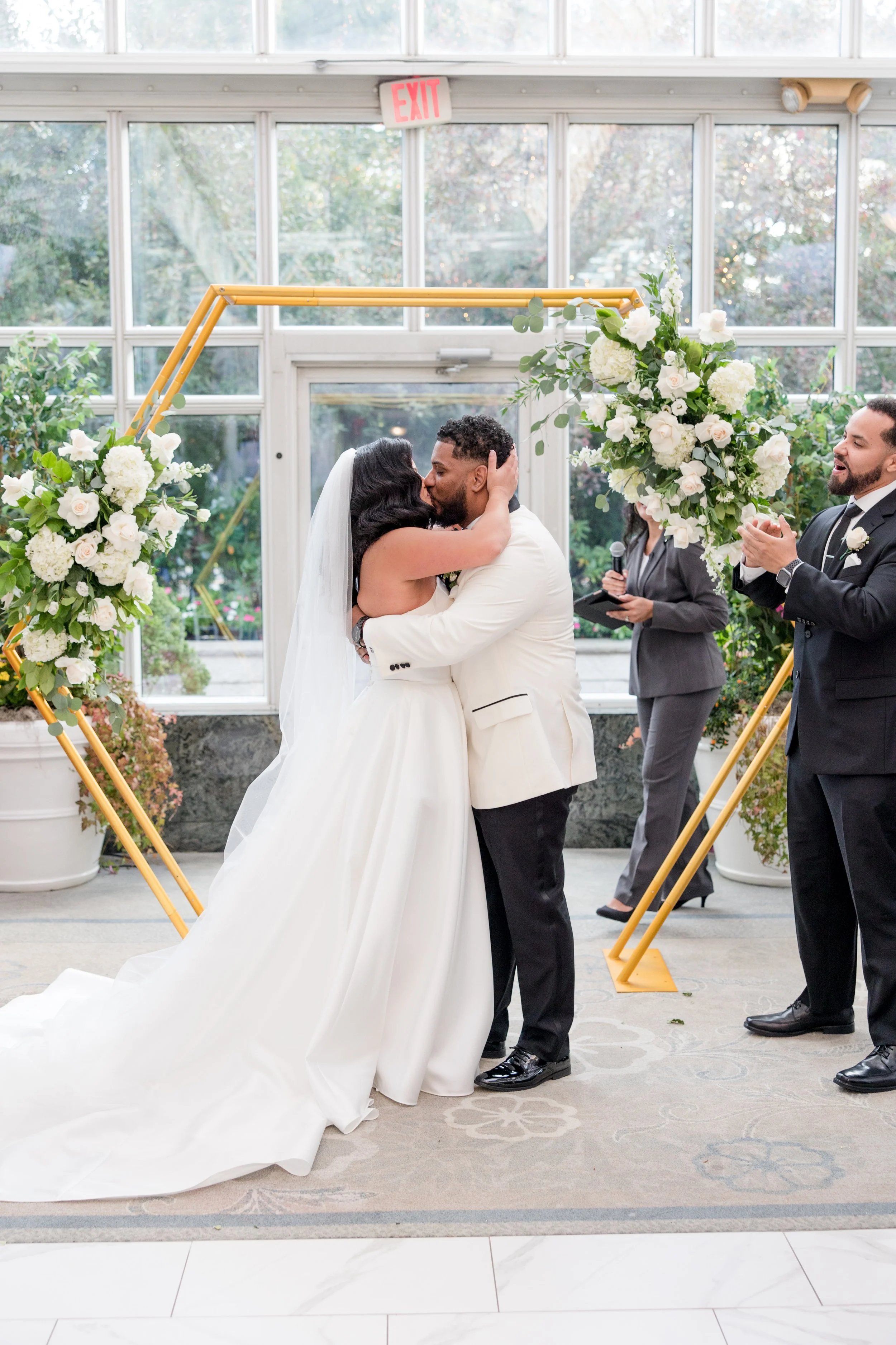 First kiss bride and groom at greenhouse wedding ceremony at The Park Savoy Estate in Florham Park, NJ. Shot by Jessica Anne Photography
