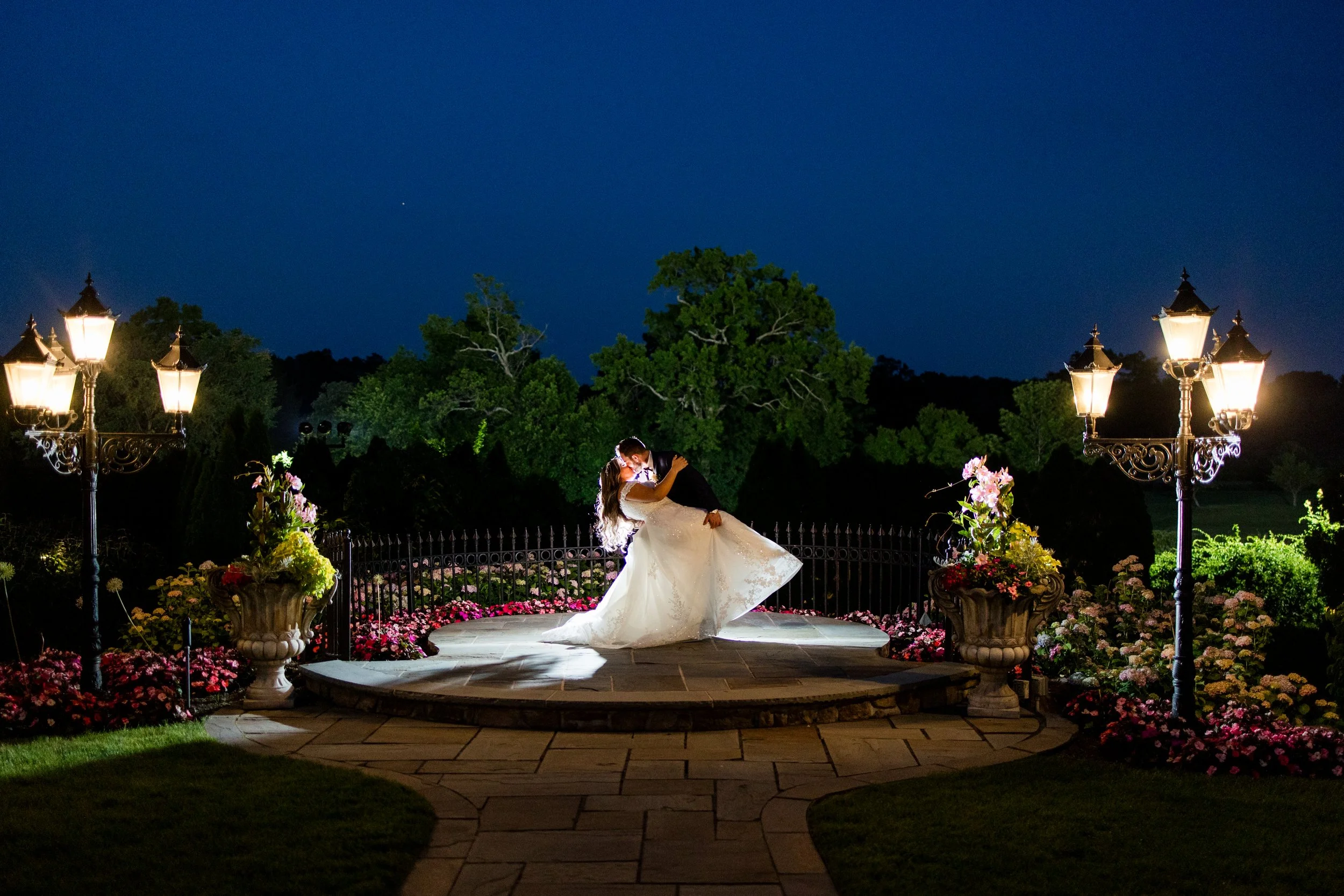 Groom dipping bride in spotlight in nighttime garden wedding photo taken at The Park Savoy Estate in Florham Park, NJ by Jessica Anne Photography
