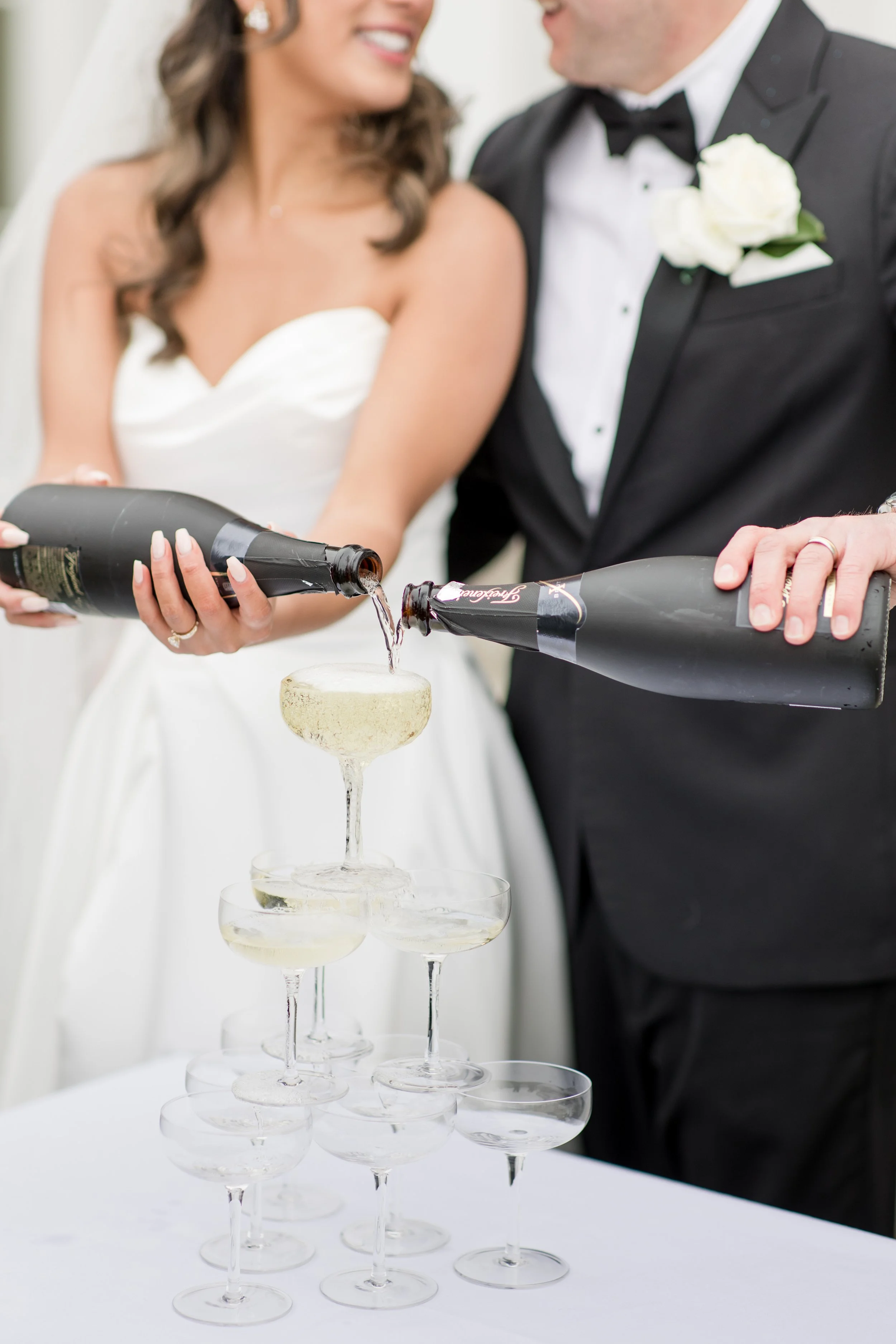 Champagne tower photo. Bride and groom pouring champagne down a pyramid of vintage champagne glasses. Captured by Jessica Anne Photography 