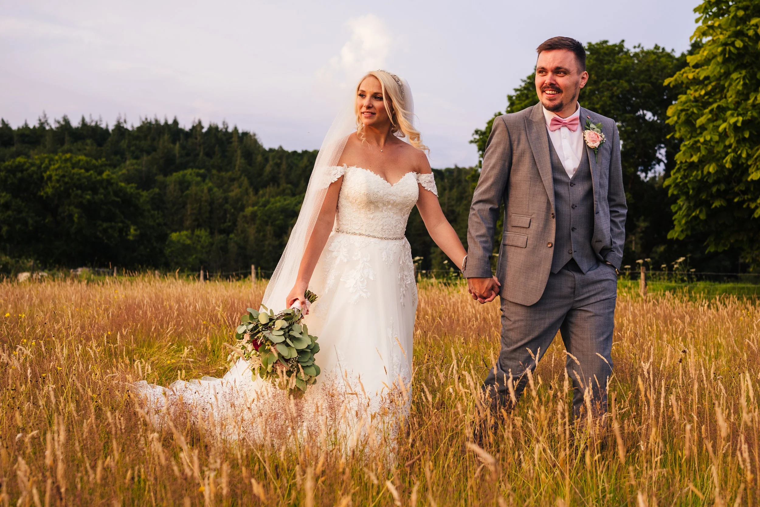 Bride-and-groom-holding-hands-meadow.jpg