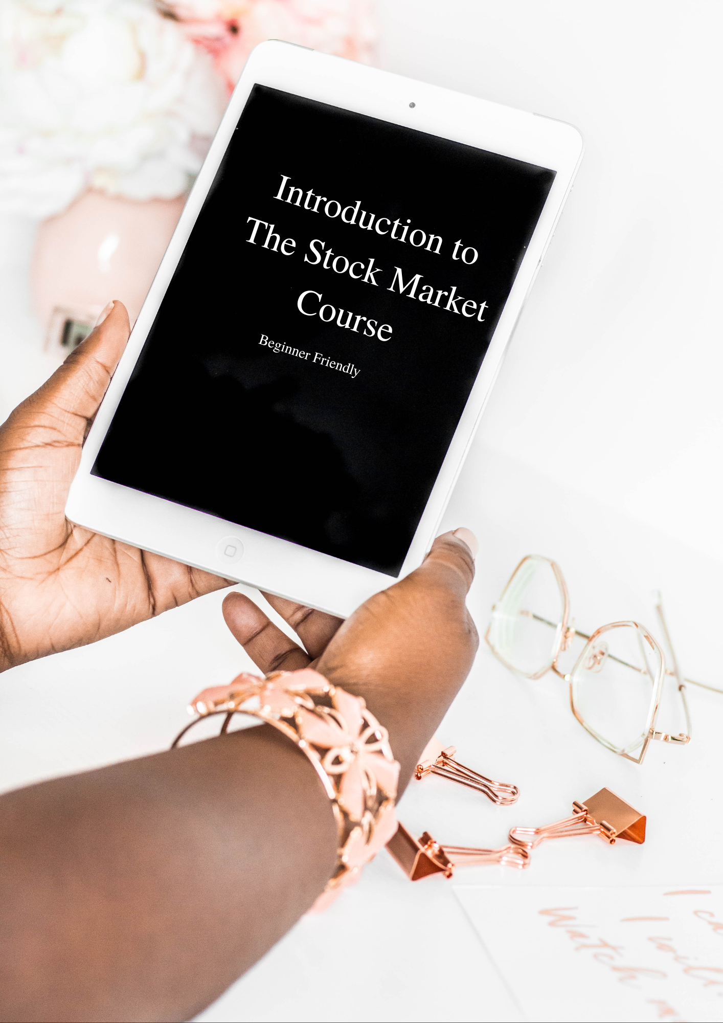 Black Woman holding notebook titled Intro to the Stock Market Class