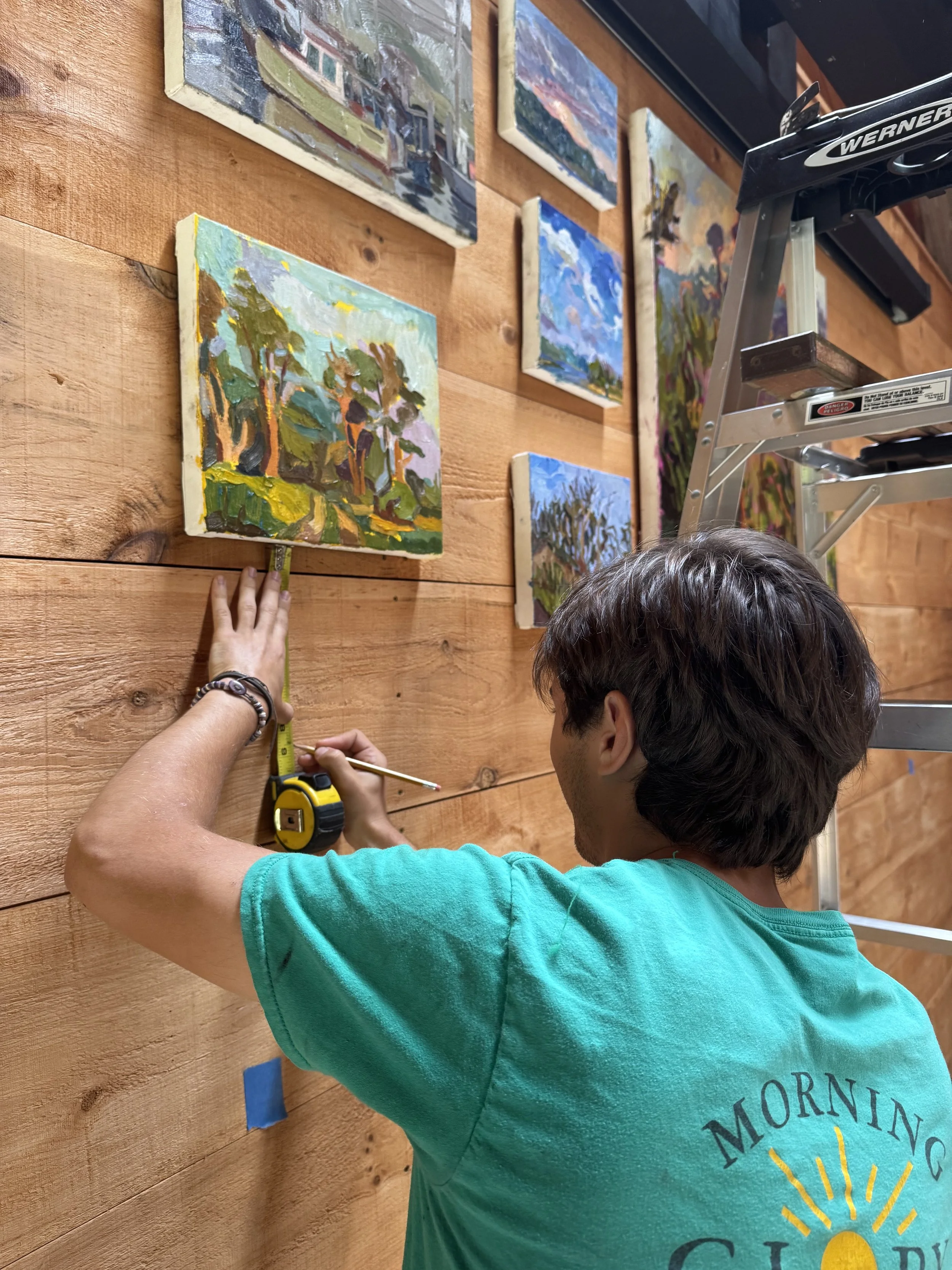 Artist Nicholas Grassi hangs paintings for his exhibition