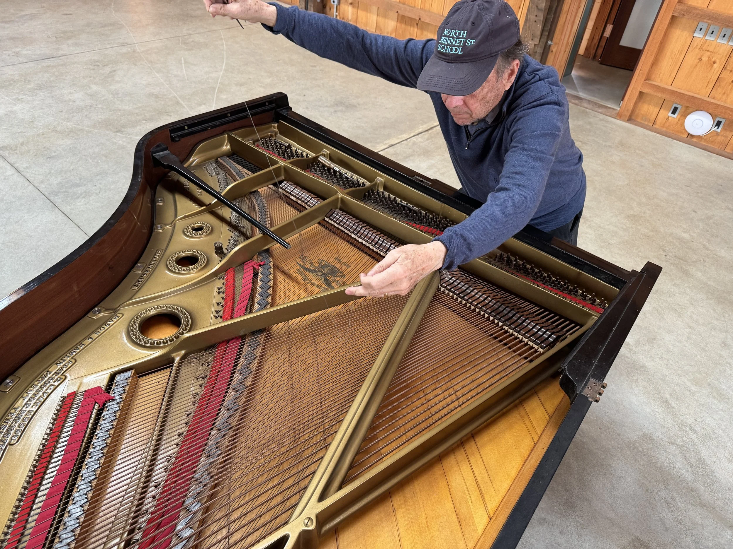 David Stanwood bows the strings of Stillpoint's piano