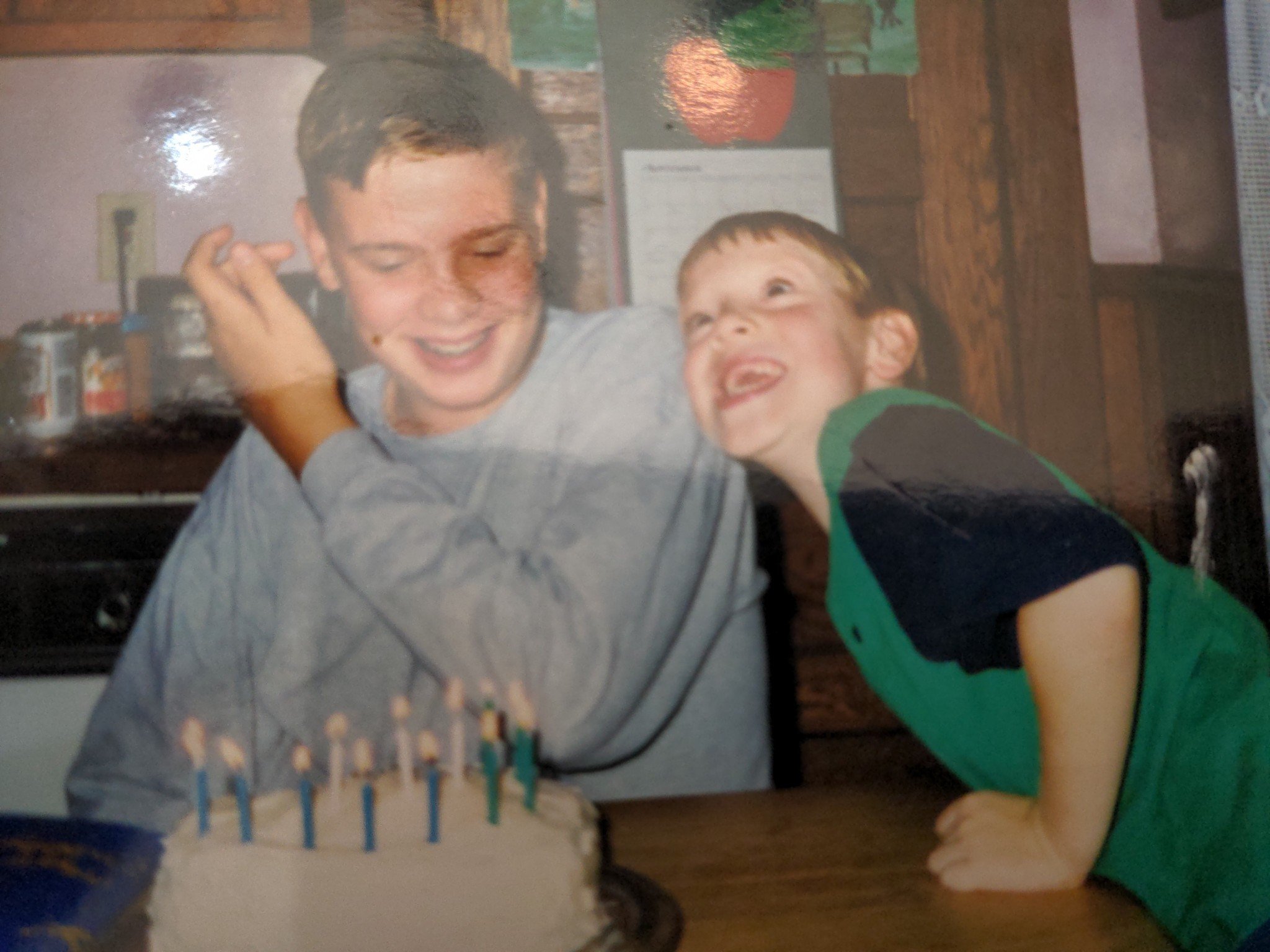 A vintage photo of Alex (left, smiling) and Luke (right, laughing) with a birthday cake, the co-hosts of the Low Five Gaming video game podcast.