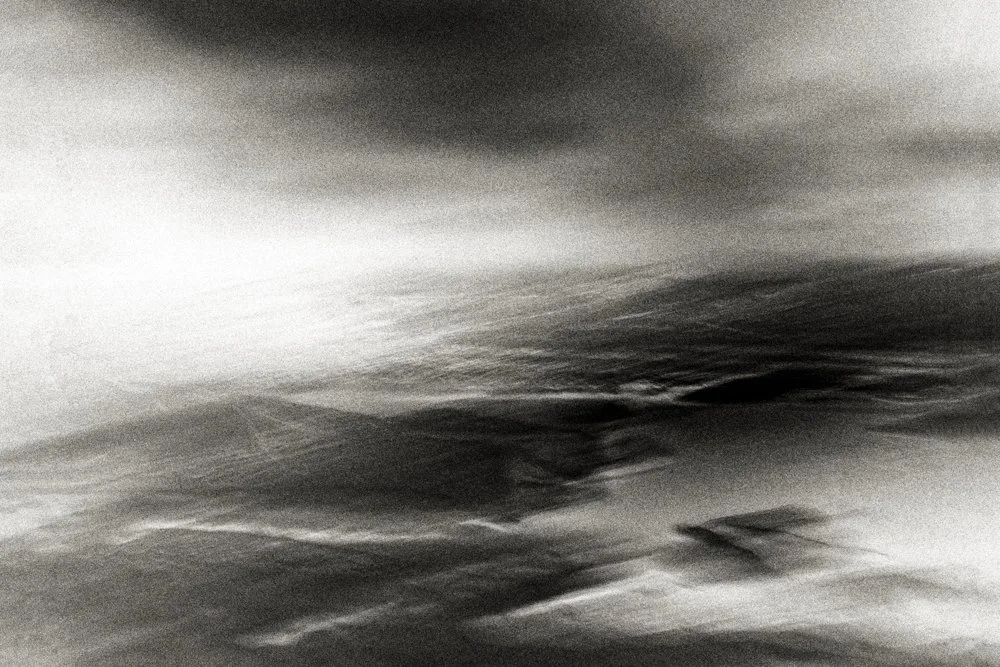 Moody black and white wave-and-tide abstraction with diagonal energy and layered surf textures, minimalist coastal fine art photography.