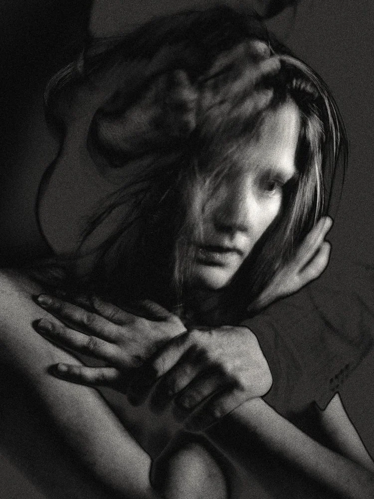 Black-and-white motion-blurred portrait of a person with long hair hugging their shoulders, creating a double-exposure effect and a contemplative mood. Fine art photography, abstract portrait.