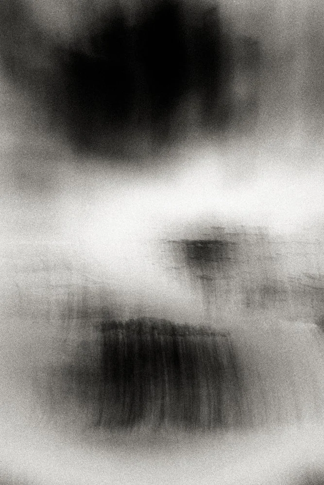 Black and white abstract landscape with a dense dark cloud mass and a bright misty band, minimalist atmospheric fine art photography.