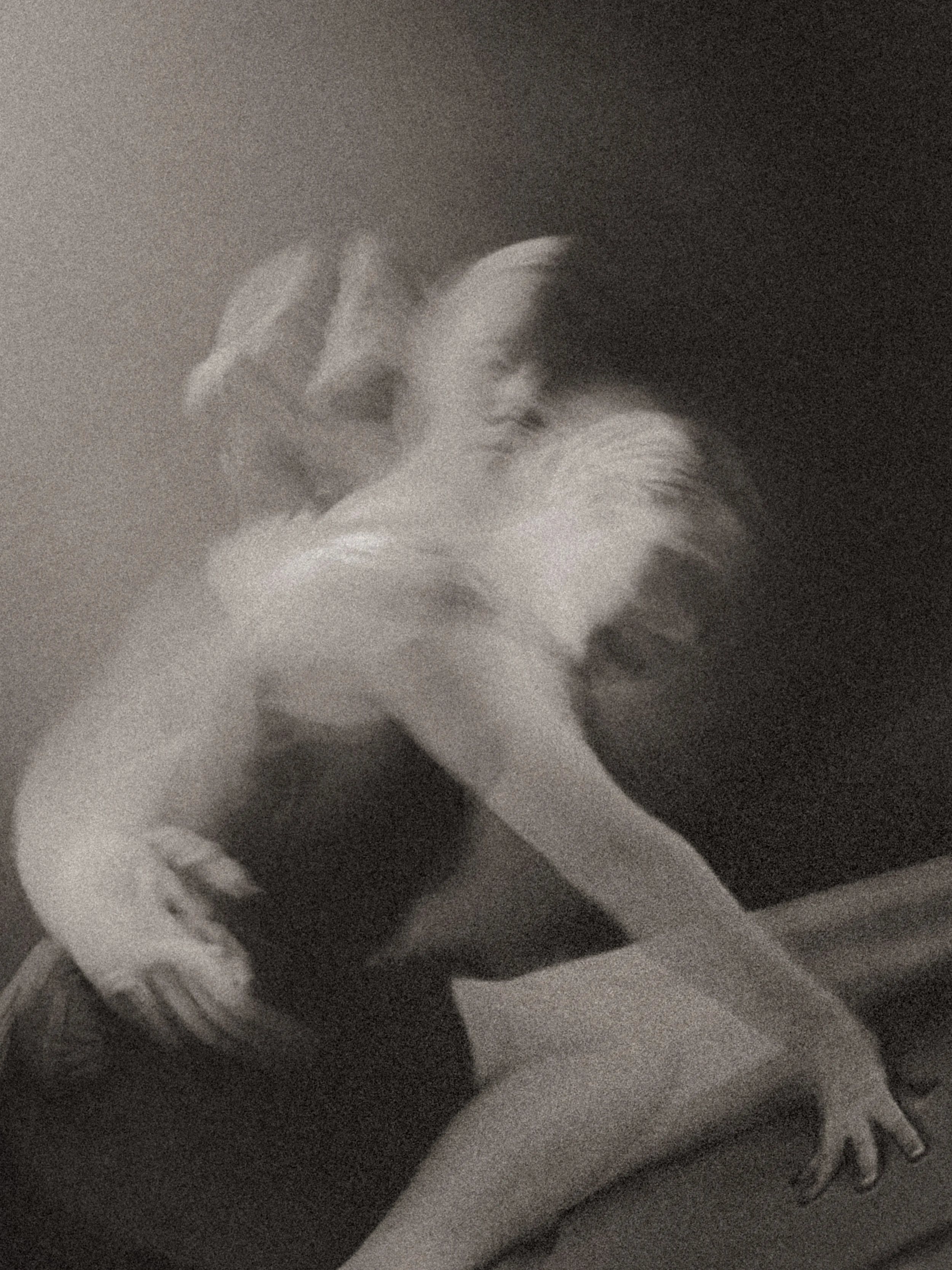 Dreamlike black-and-white nude figure in motion blur, arms reaching and body unfolding in layered exposures—an expressive fine art study of becoming, instability, and embodied transformation.