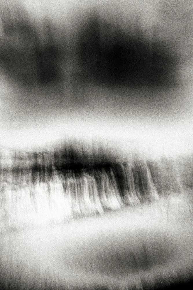 High-contrast abstract black and white storm-cloud field with blurred motion and layered tonal bands, cinematic minimalist landscape photograph.