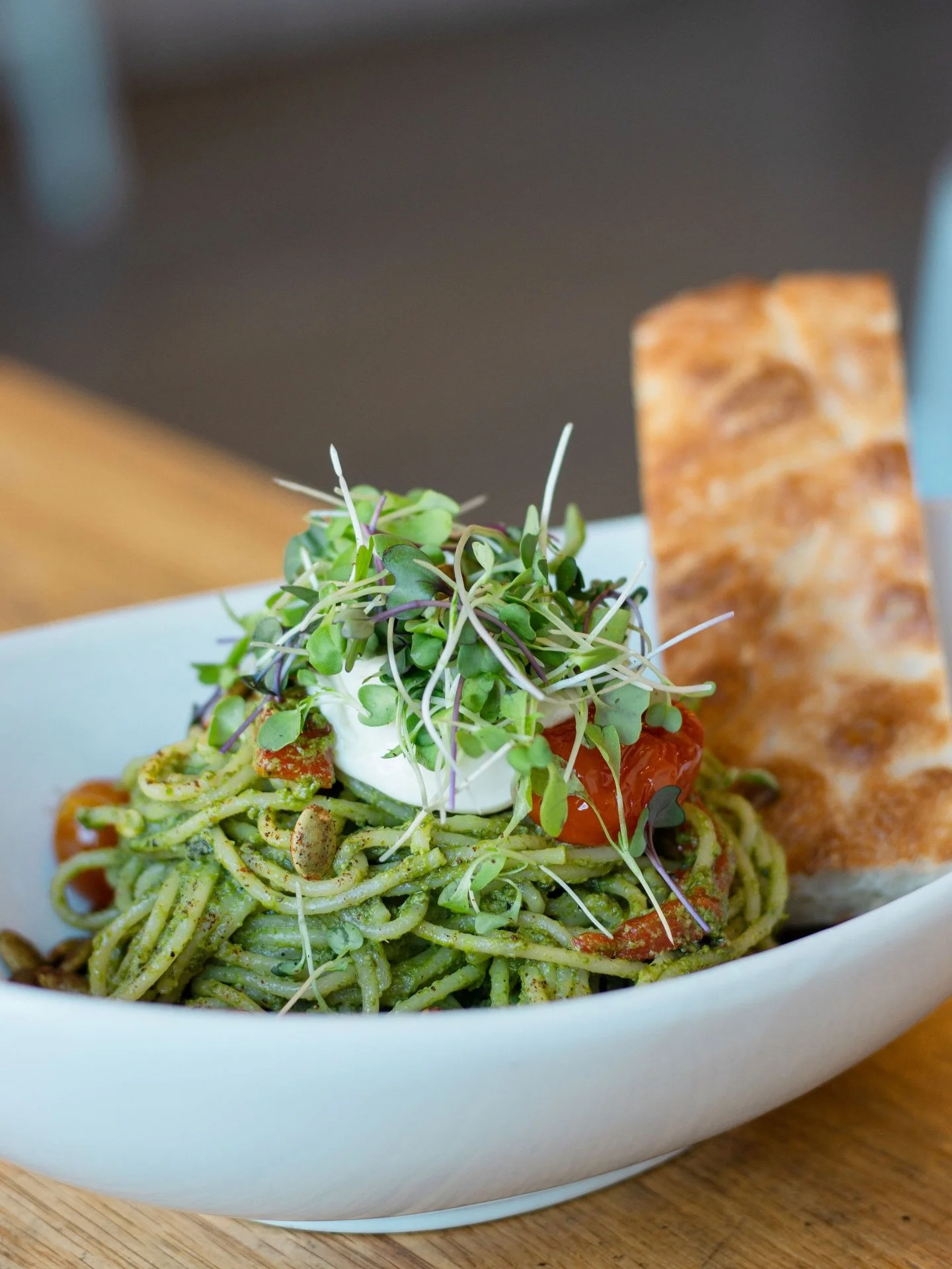 Our Patient Pesto Pasta is a hit! 

Spaghetti tossed in kale + pepita pesto, layered with roasted red peppers, confit cherry tomatoes, whipped lemon ricotta, crunchy spiced pepitas, sprouts, and served with toasted herb focaccia.

Comes with 26g of p