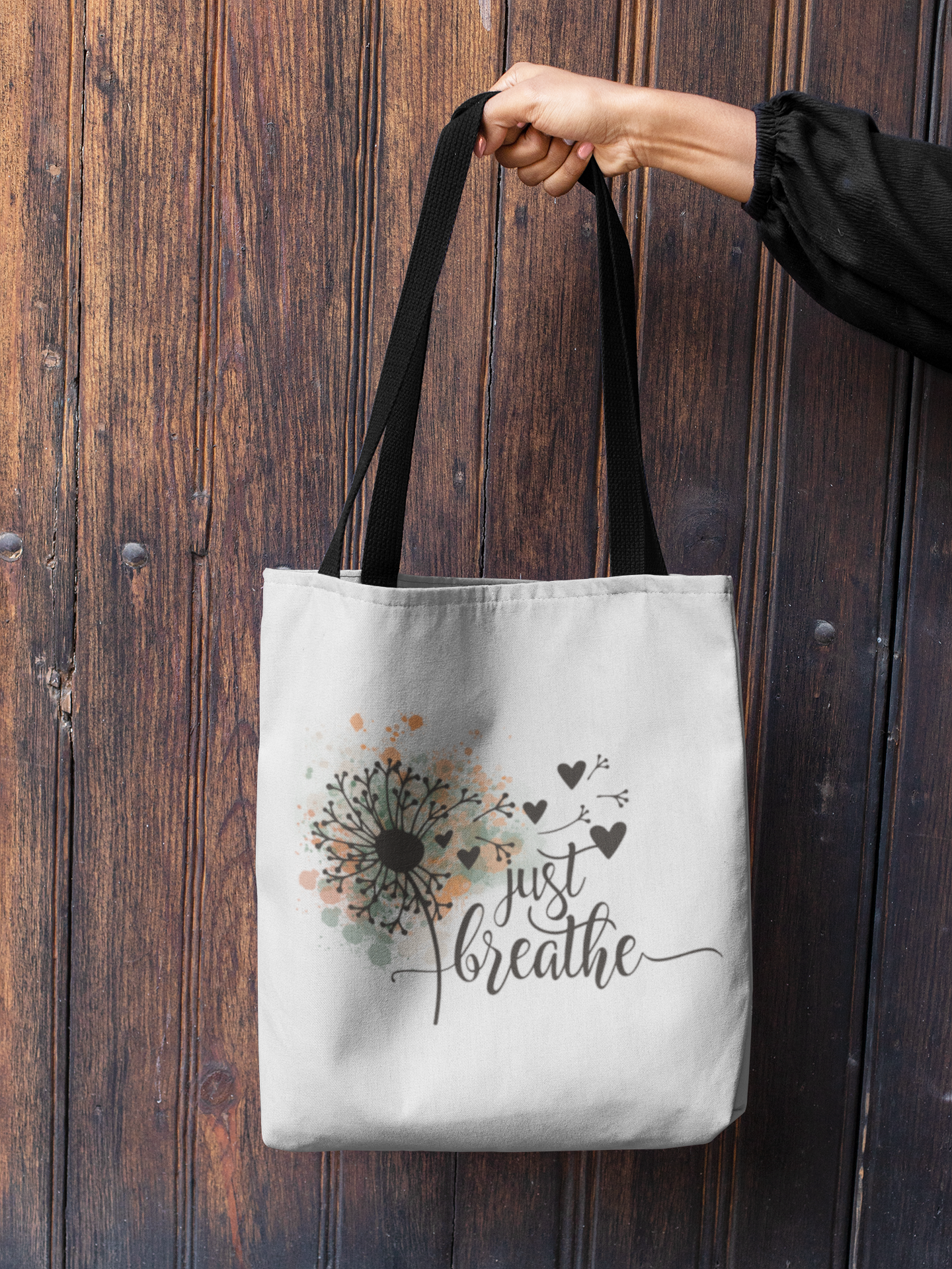 mockup-of-a-woman-s-hand-holding-a-tote-bag-against-a-wooden-background-26693.png