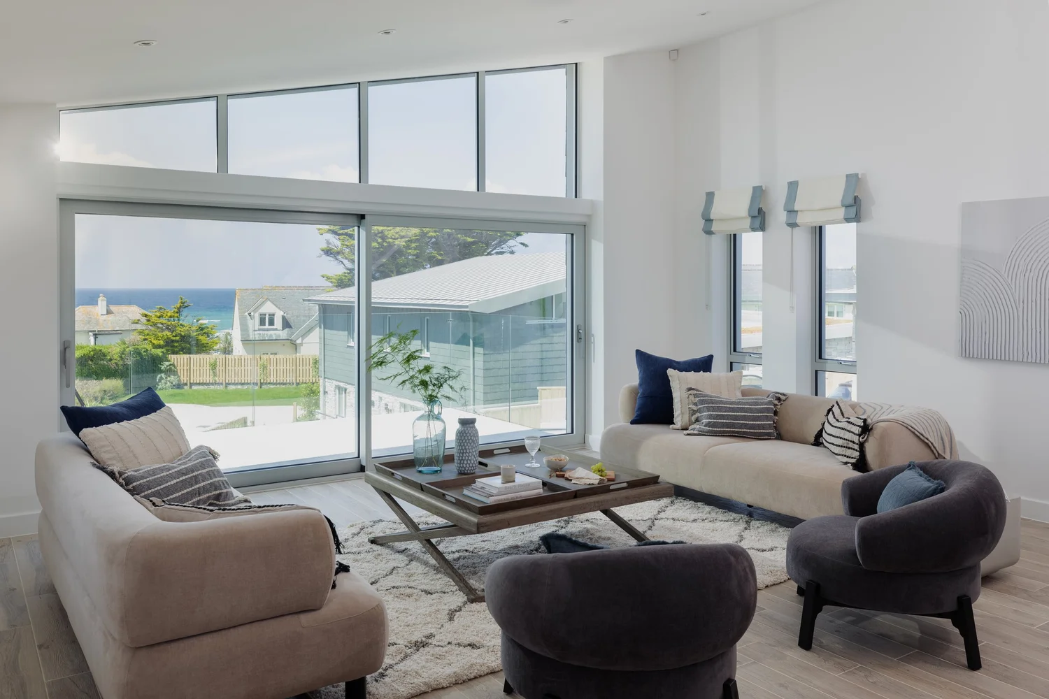 Open plan living room with sea view through floor to ceiling glass, Waterbeach Mews