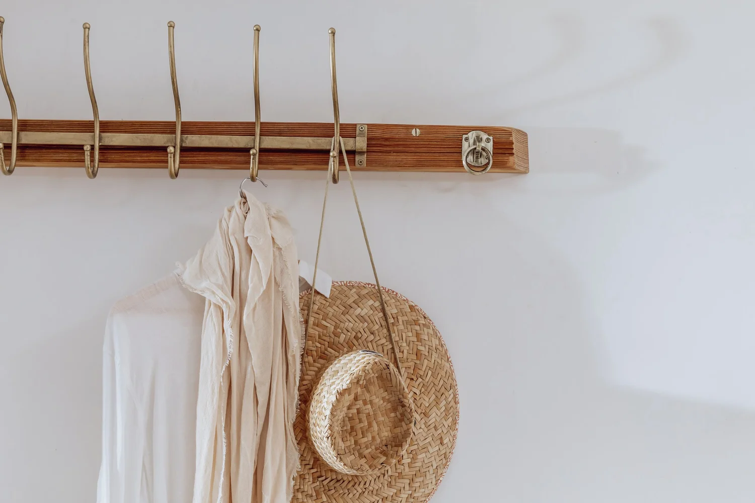 Straw hats on oak hooks at The Rafters, St Agnes, photographed by Pip Hambling