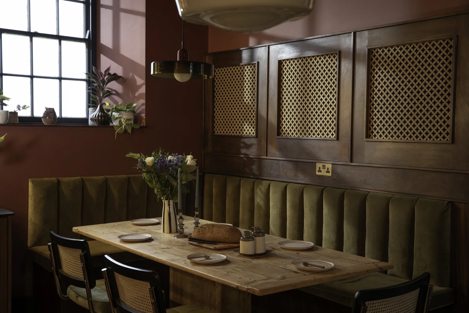 Oxblood dining room with green velvet banquette at Zennor Sounds Studio, Cornwall, by Studio Far West