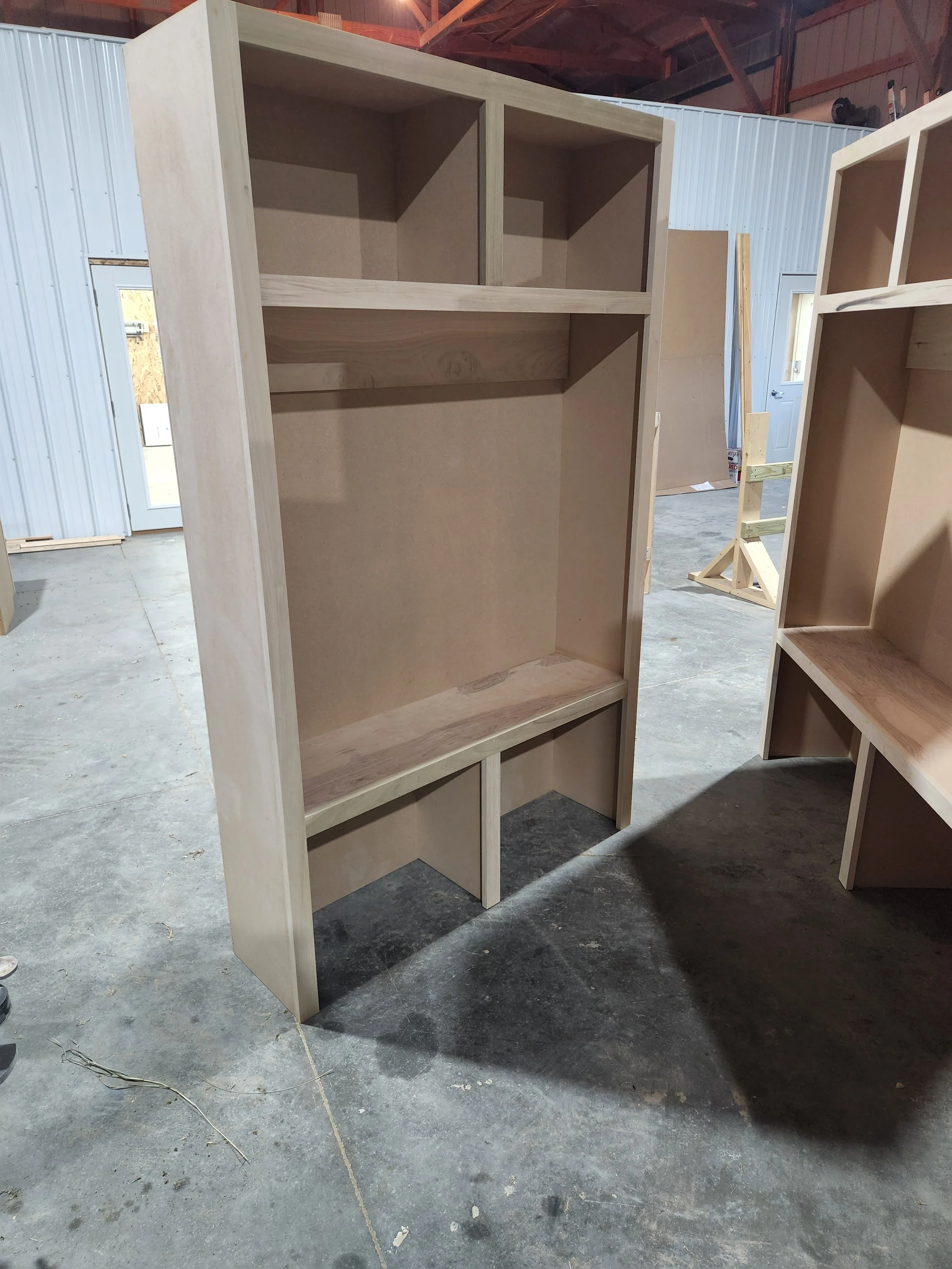Unfinished wooden bookshelf or storage unit in a workshop.